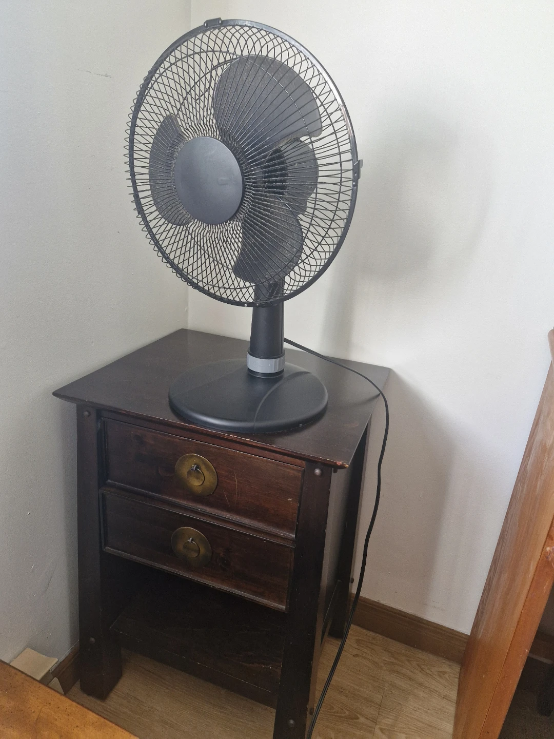 Black oscillating desk fan with desk