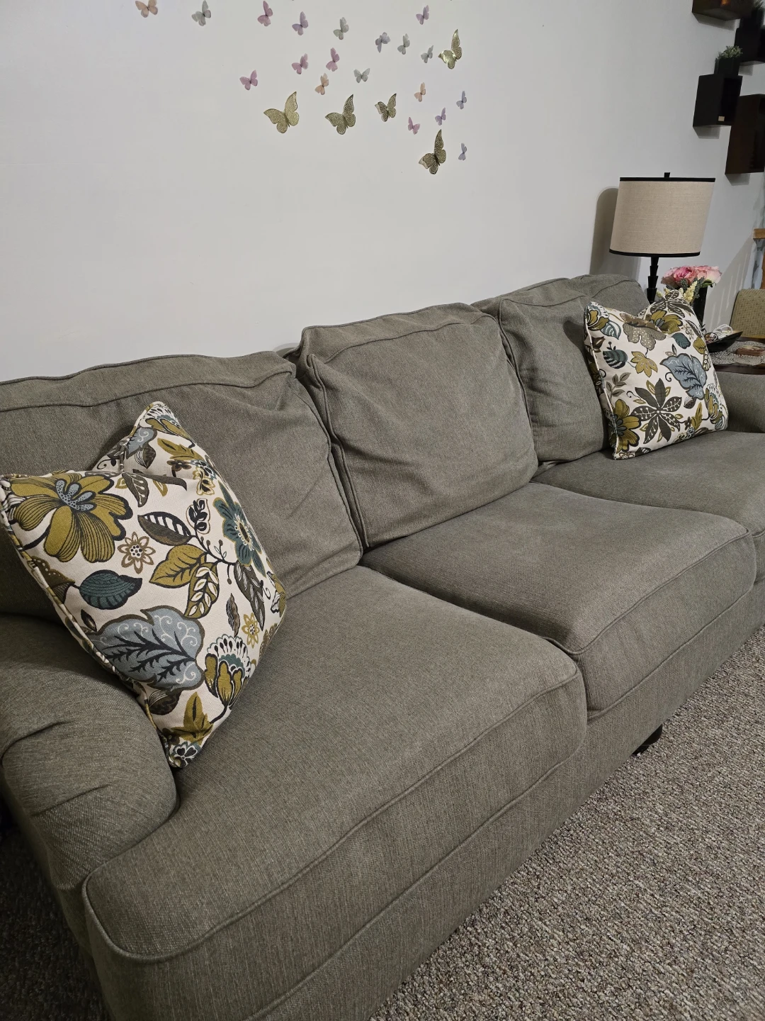 2 Grey Three-Seater Sofa with Floral Accent Pillows