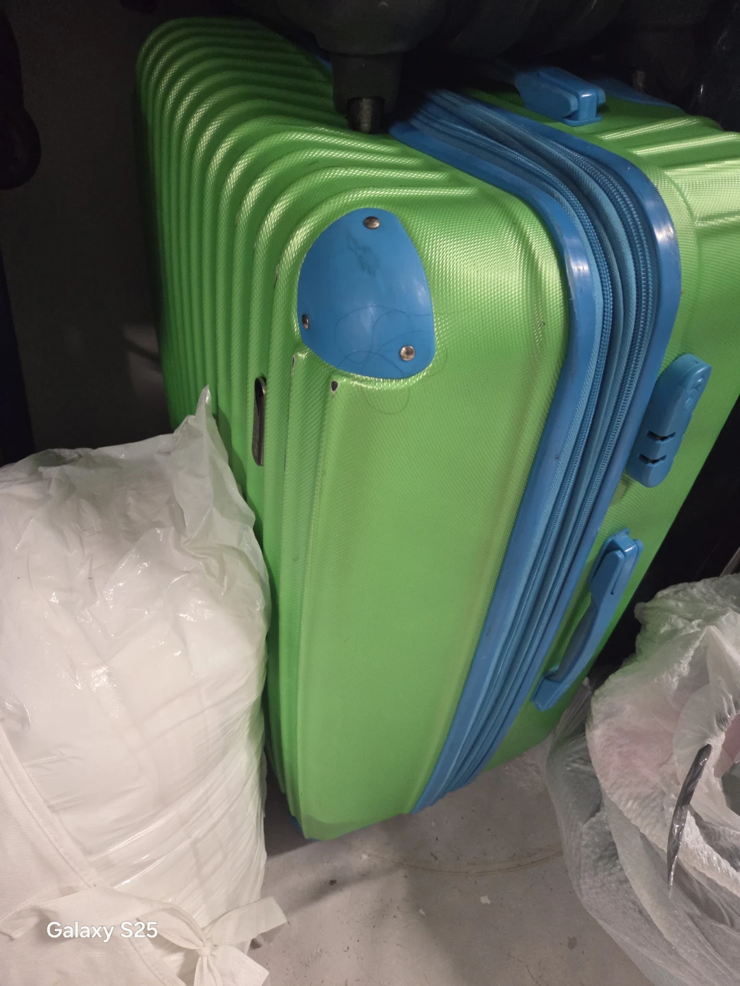 Green hard-shell suitcase with blue accents