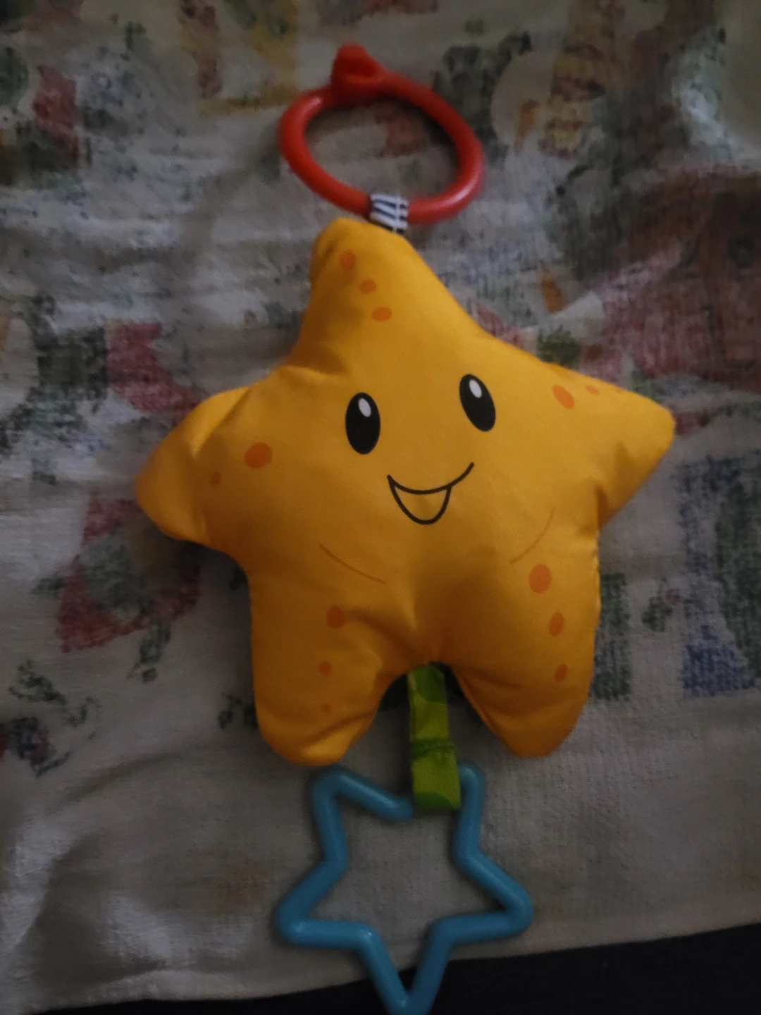 yellow Infantino star-shaped baby toy with a red hanging clip