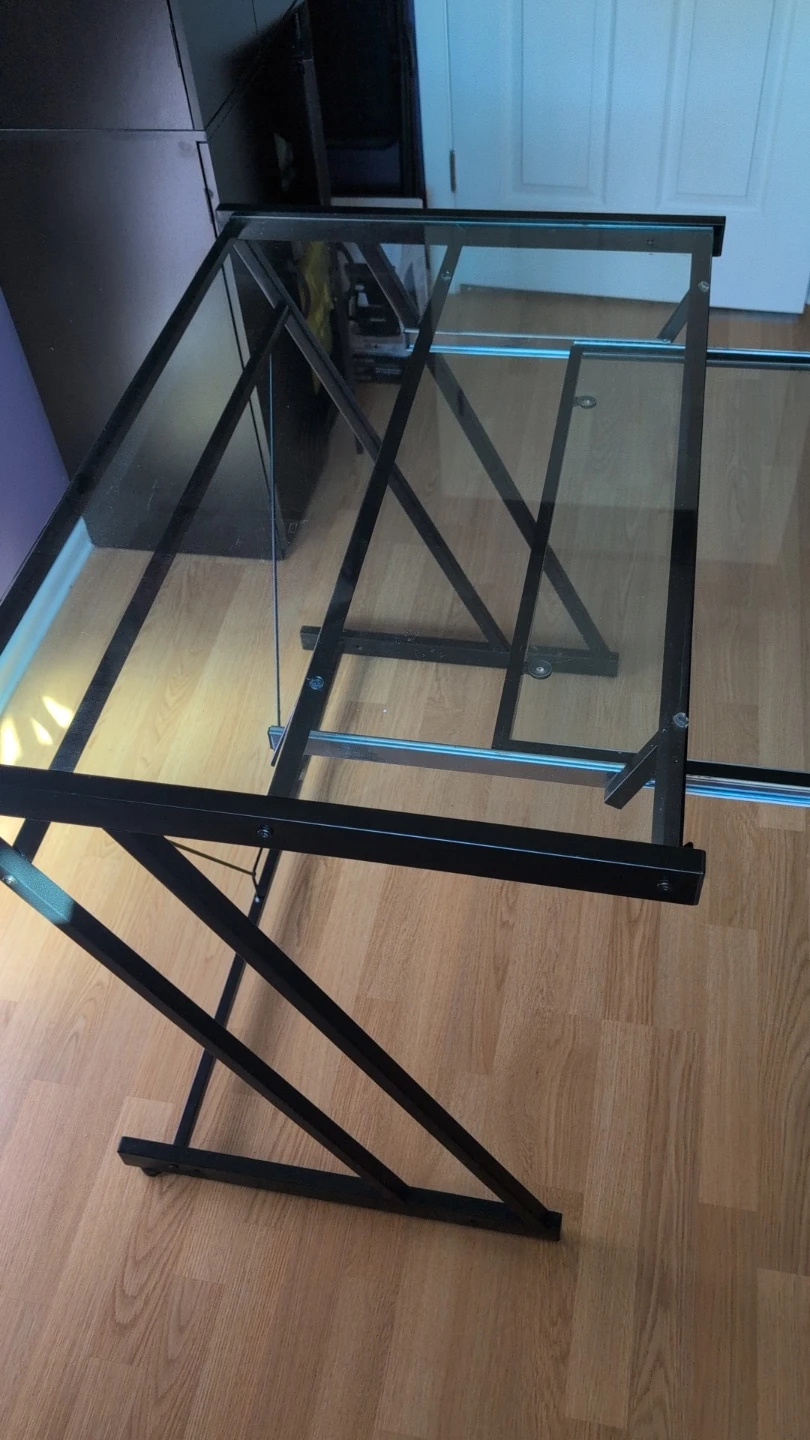 Glass top desk with black metal frame and chair mat