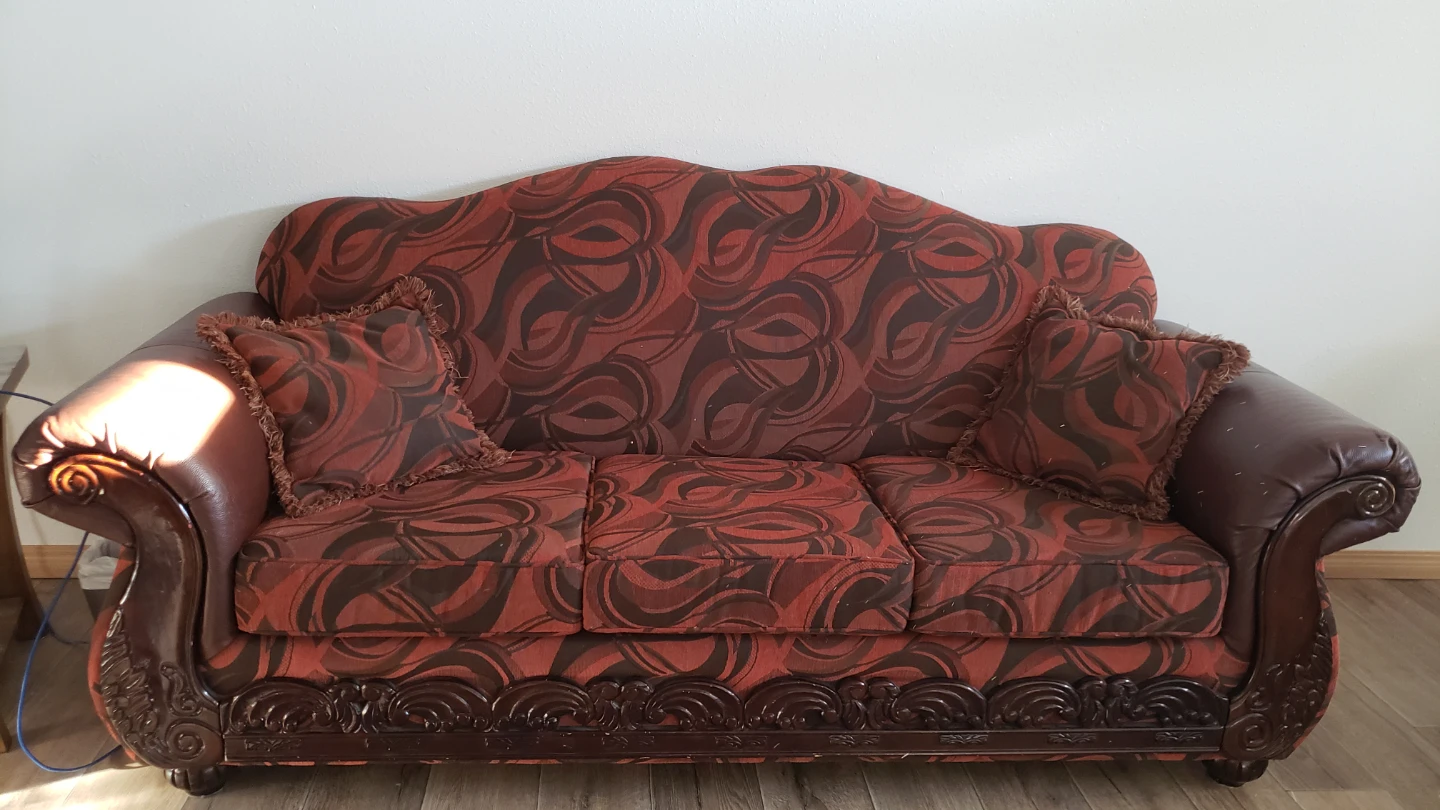 Sofa with ornate wood trim and patterned upholstery