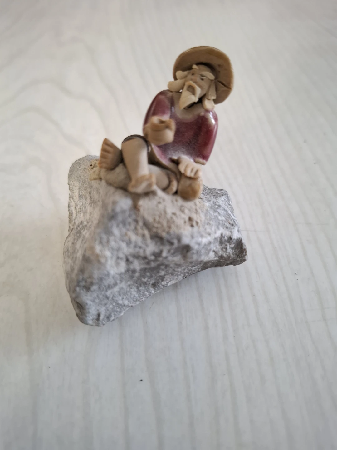 Ceramic Figurine of Man on Rock