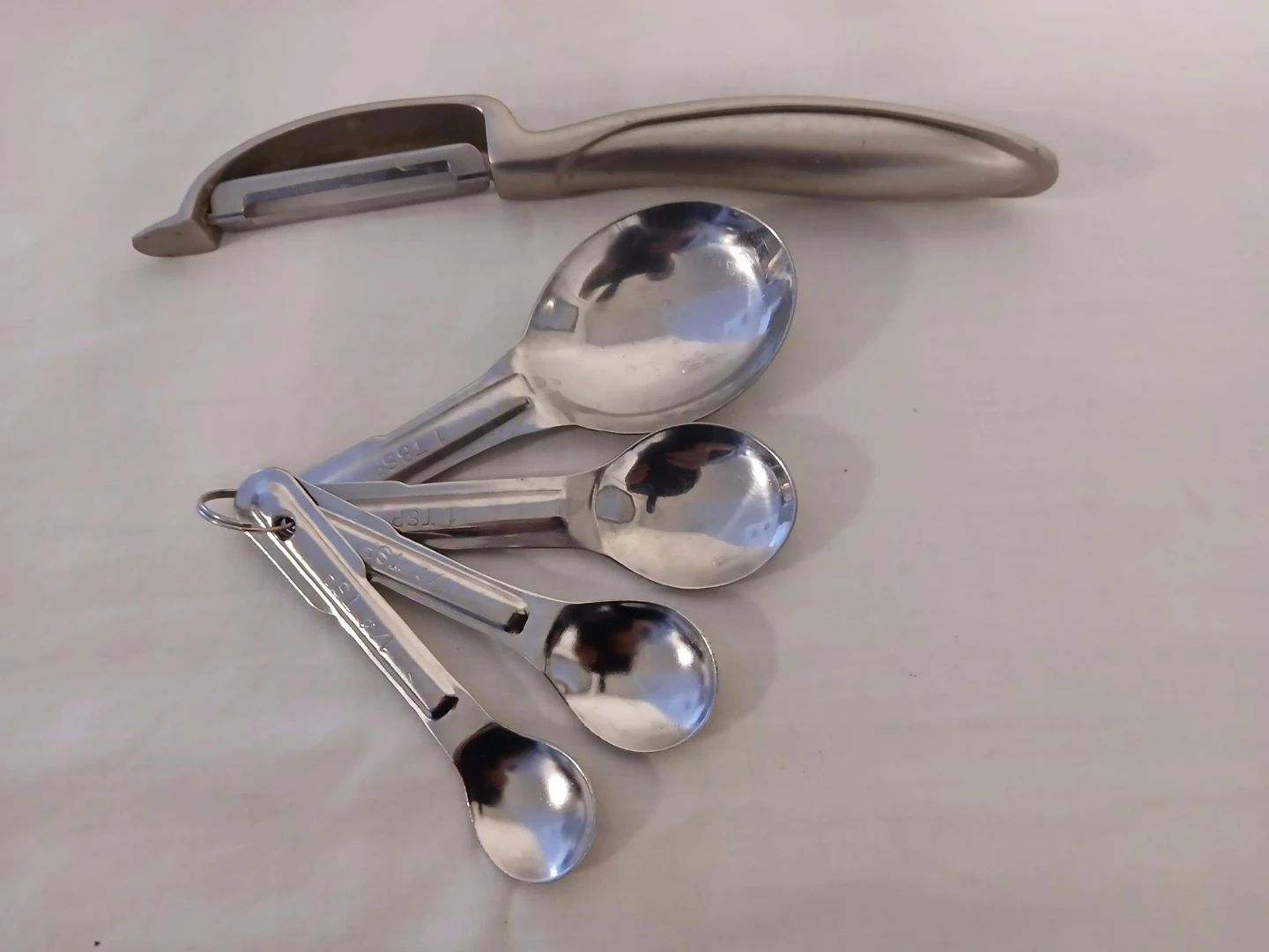 Stainless Steel Peeler and Measuring Spoons Set. Both $6.