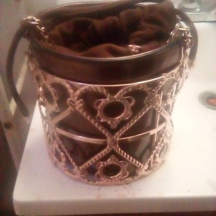 Brown drawstring bucket bag with ornate gold cage