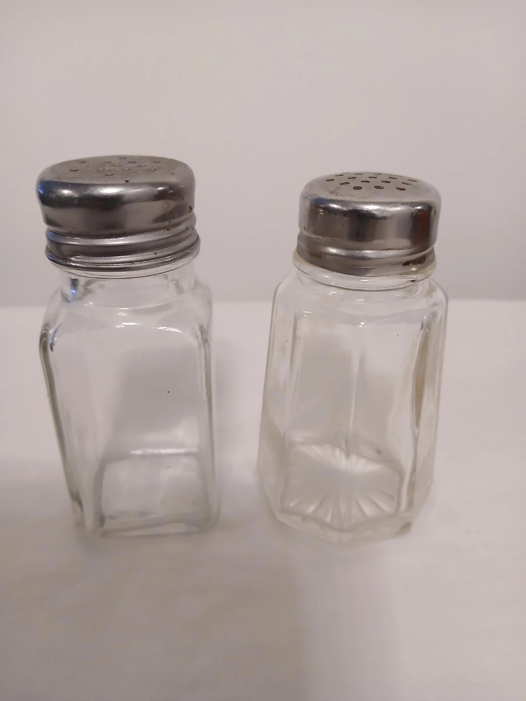 2 Glass Salt and Pepper Shakers with Metal Tops. Pick up only.
