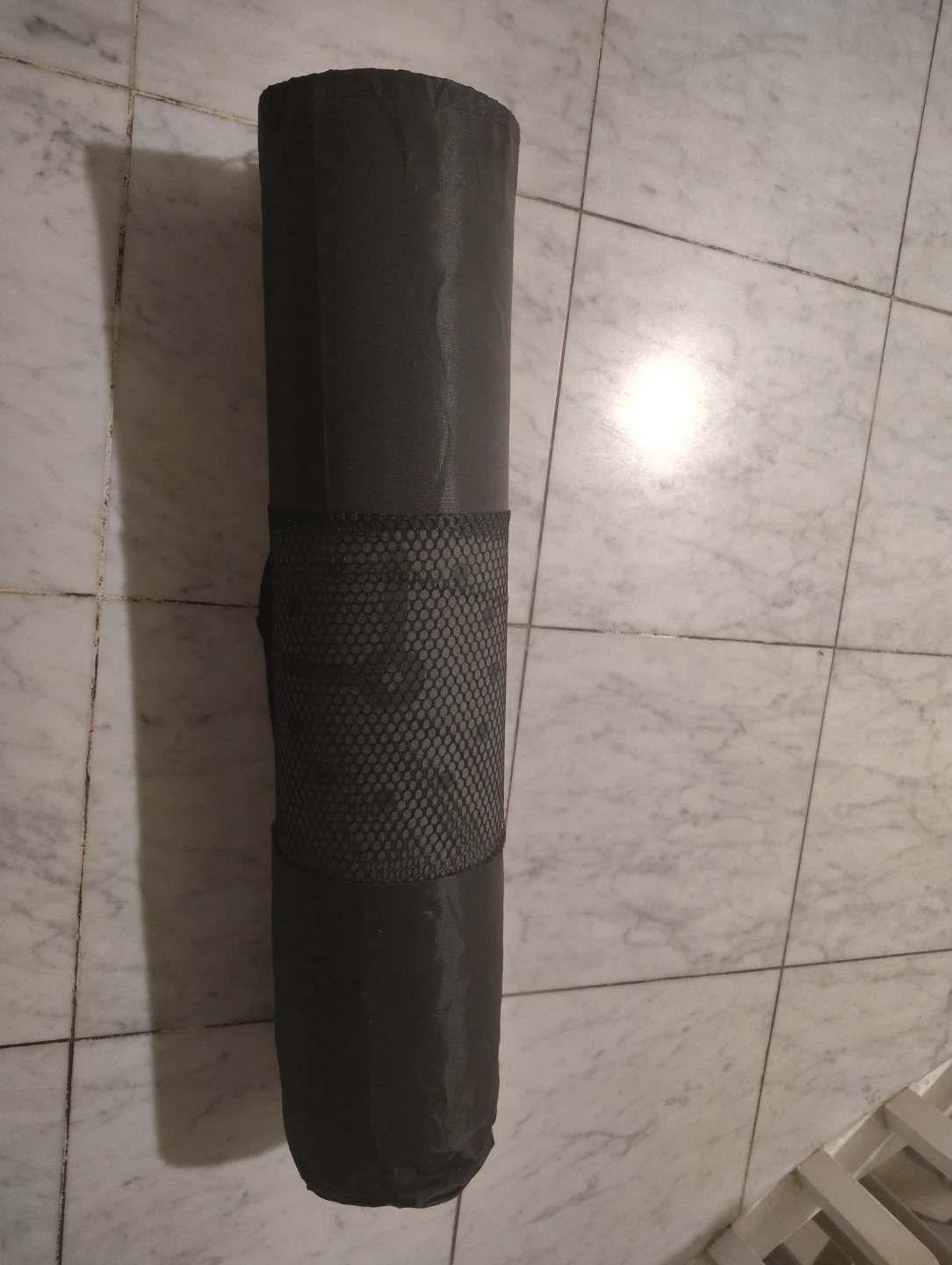 Rolled up dark grey yoga mat