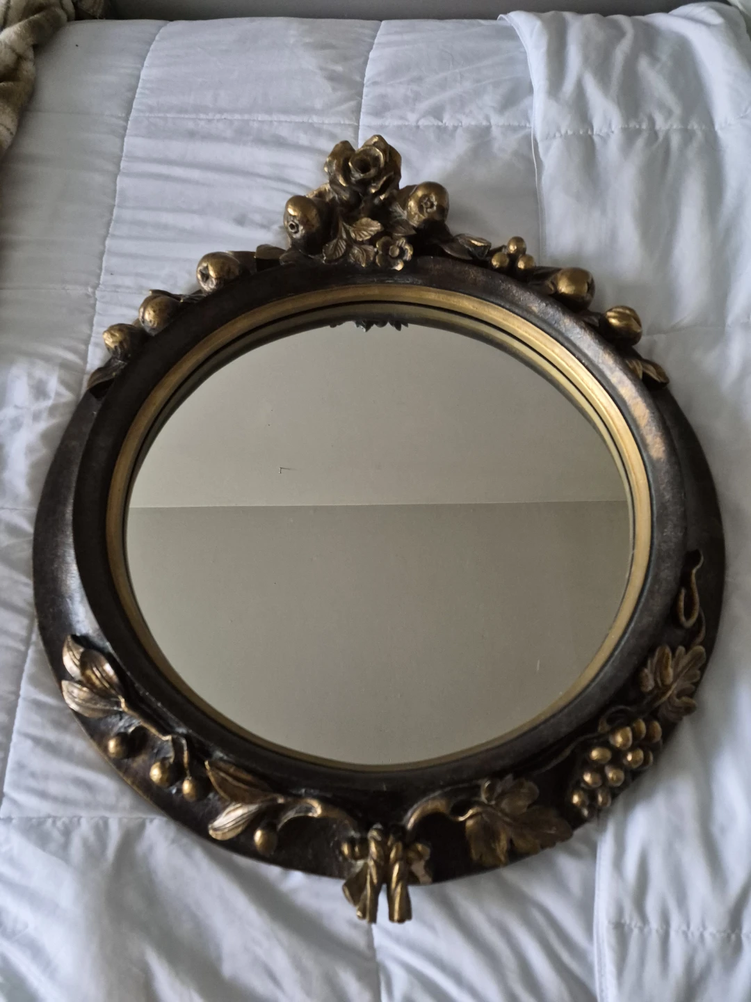 Oval decorative mirror with ornate gold frame
