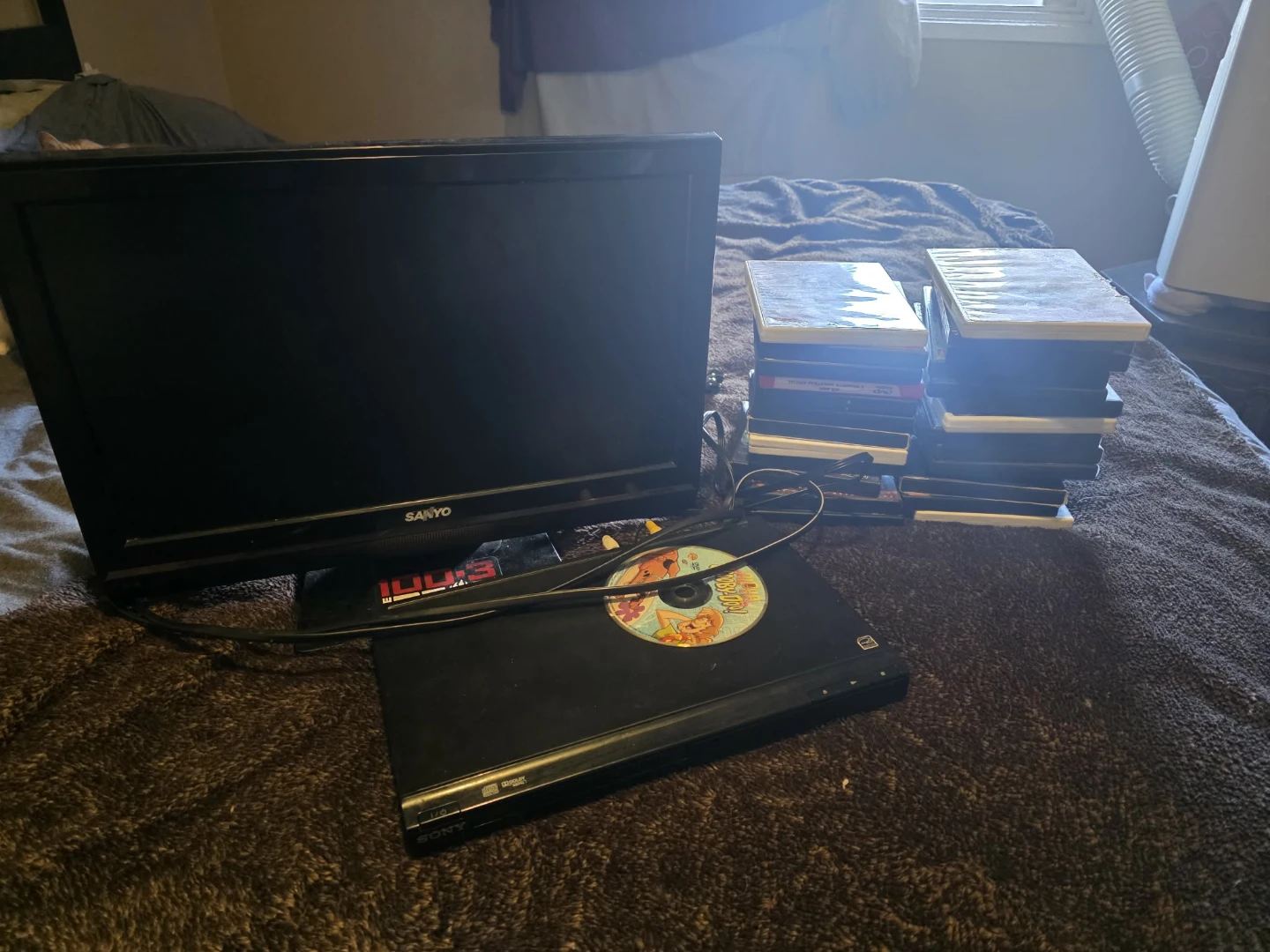 Sanyo TV with Sony DVD Player and Stack of DVDs