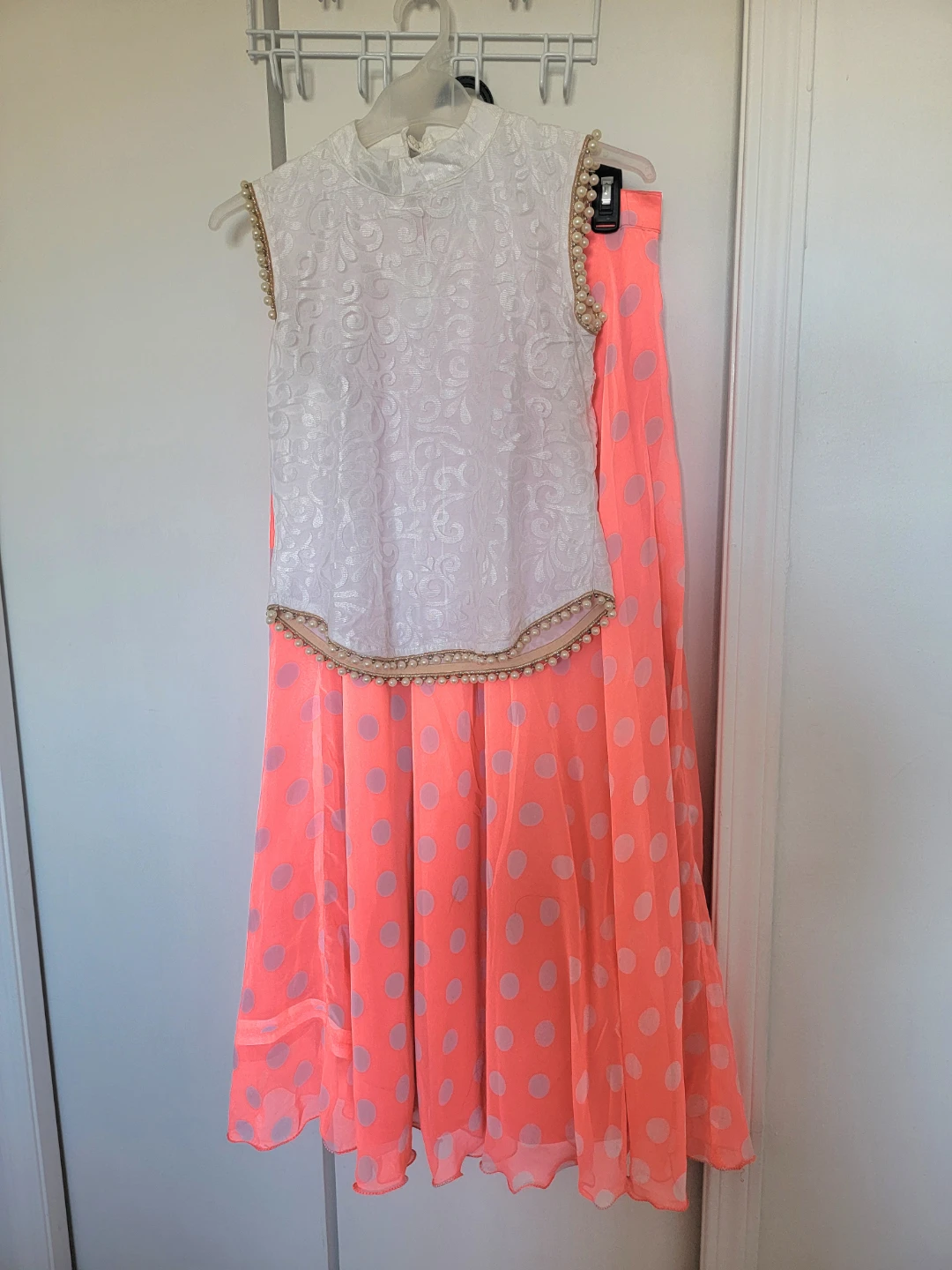 White pearl-embellished top and coral polka dot skirt set