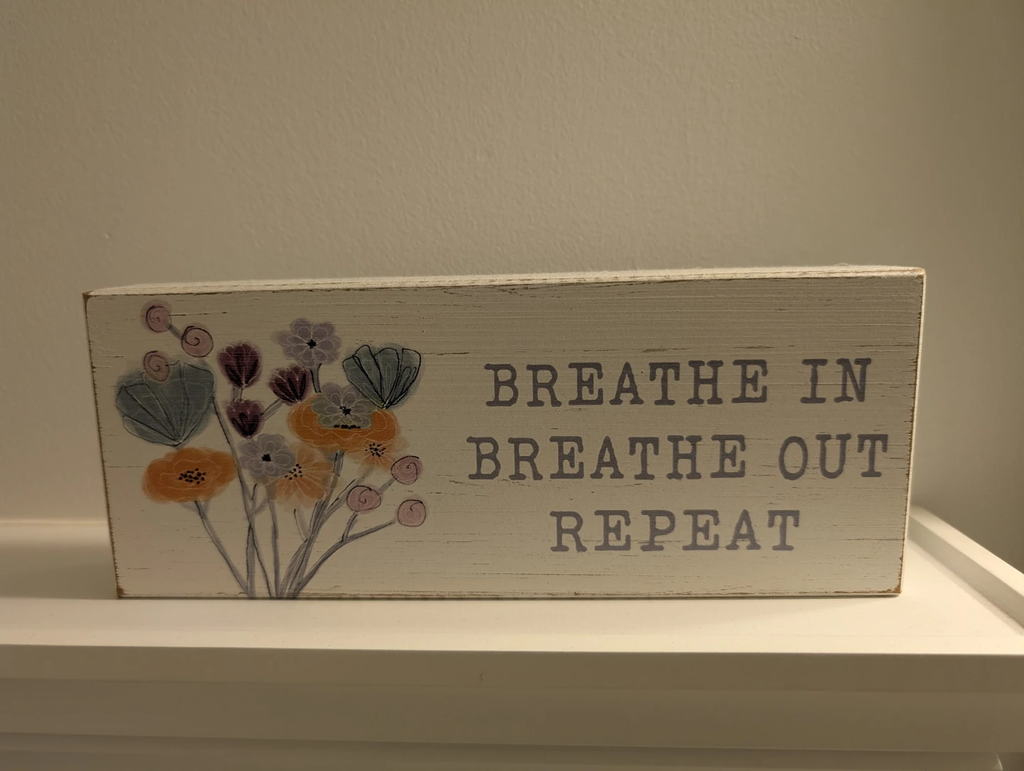 Wooden sign with floral design and motivational text