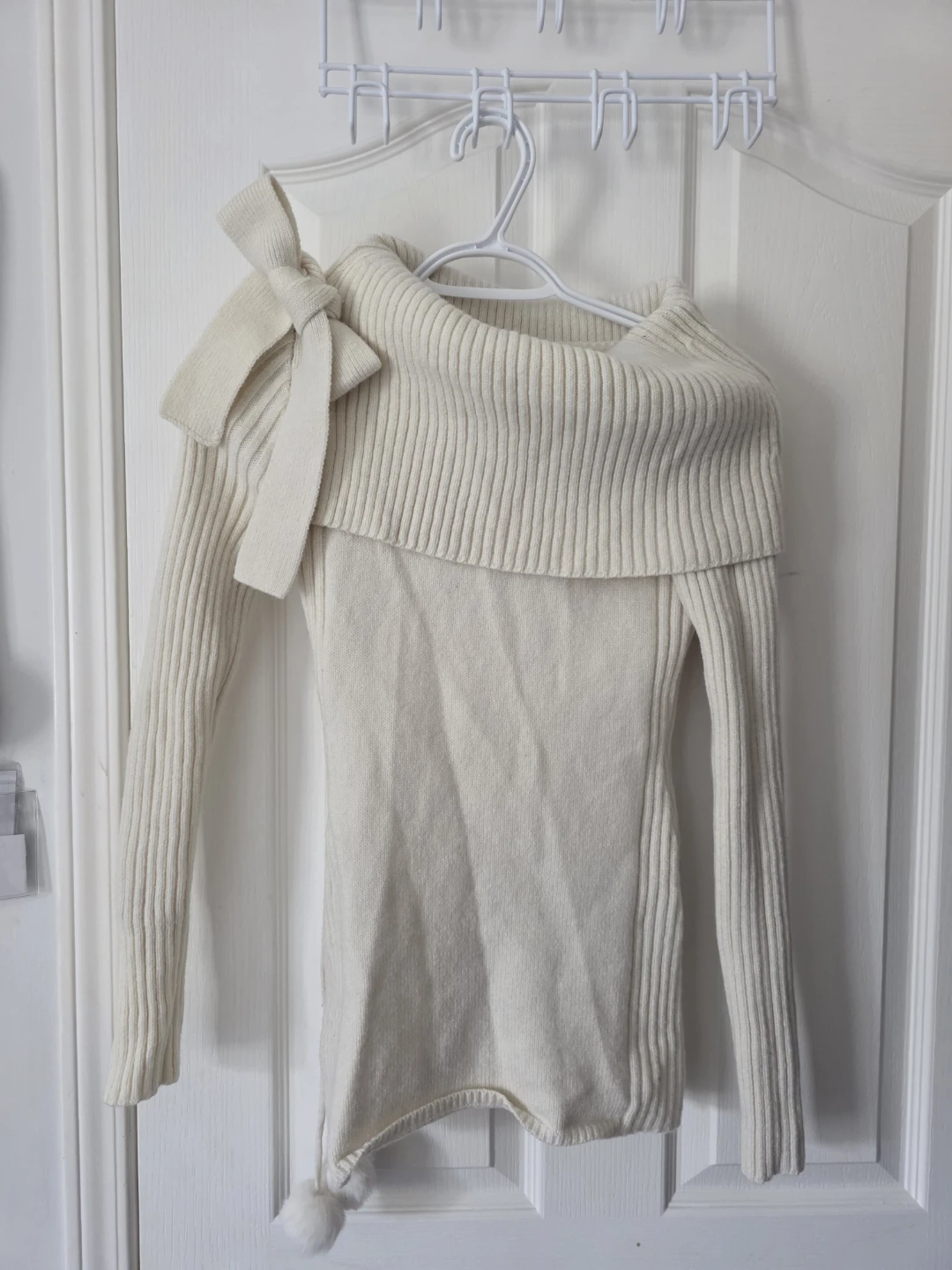 Cream off-the-shoulder sweater with pom-pom details