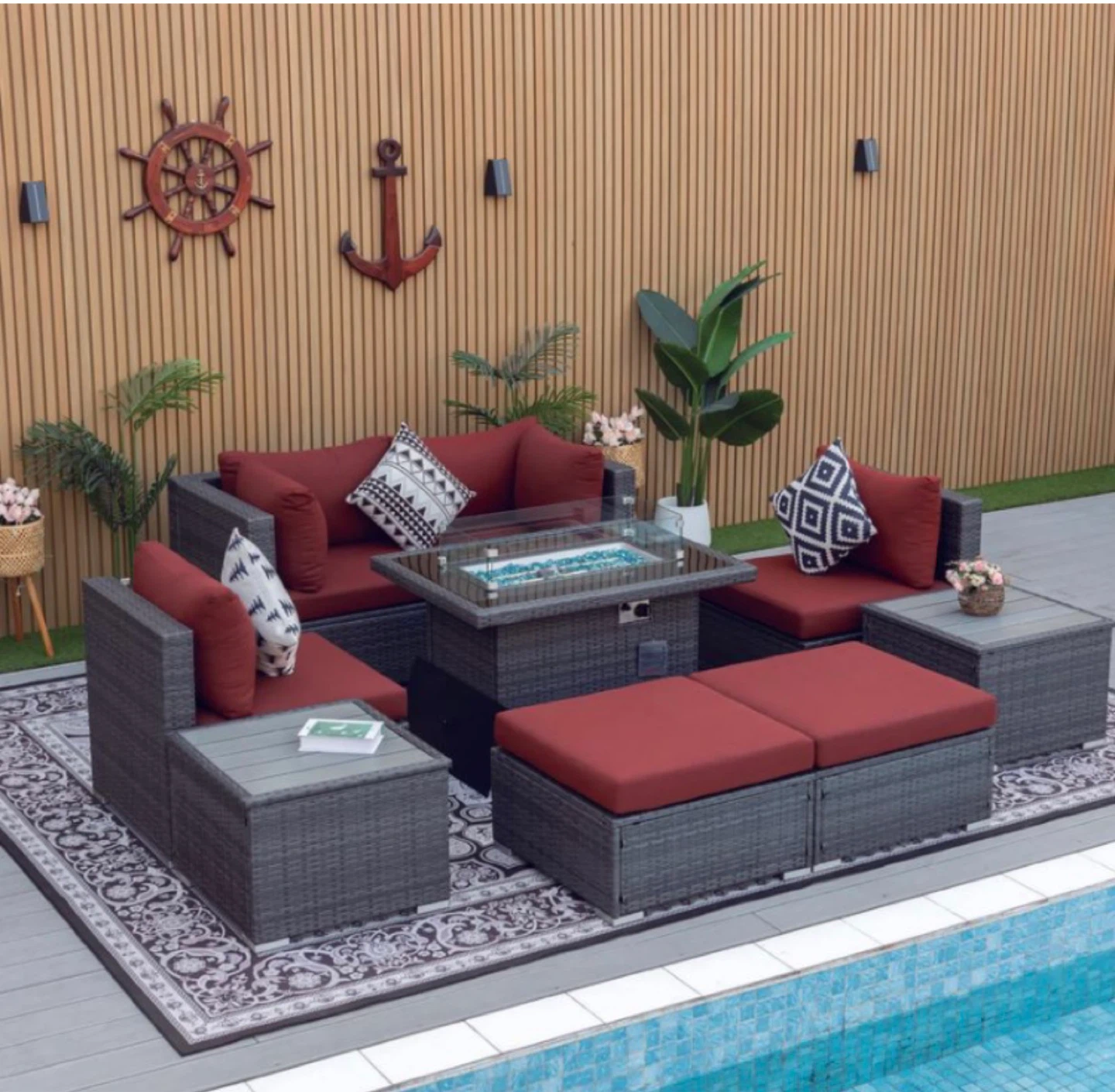 Wicker patio furniture set with fire pit and red cushions