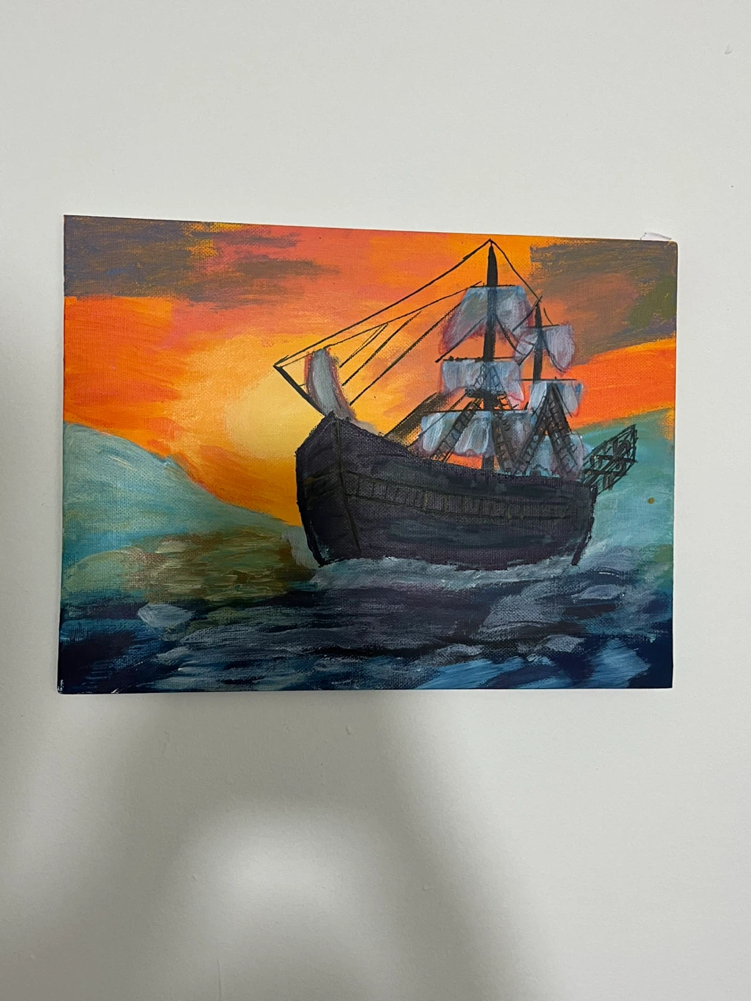 Painting of a sailing ship at sunset