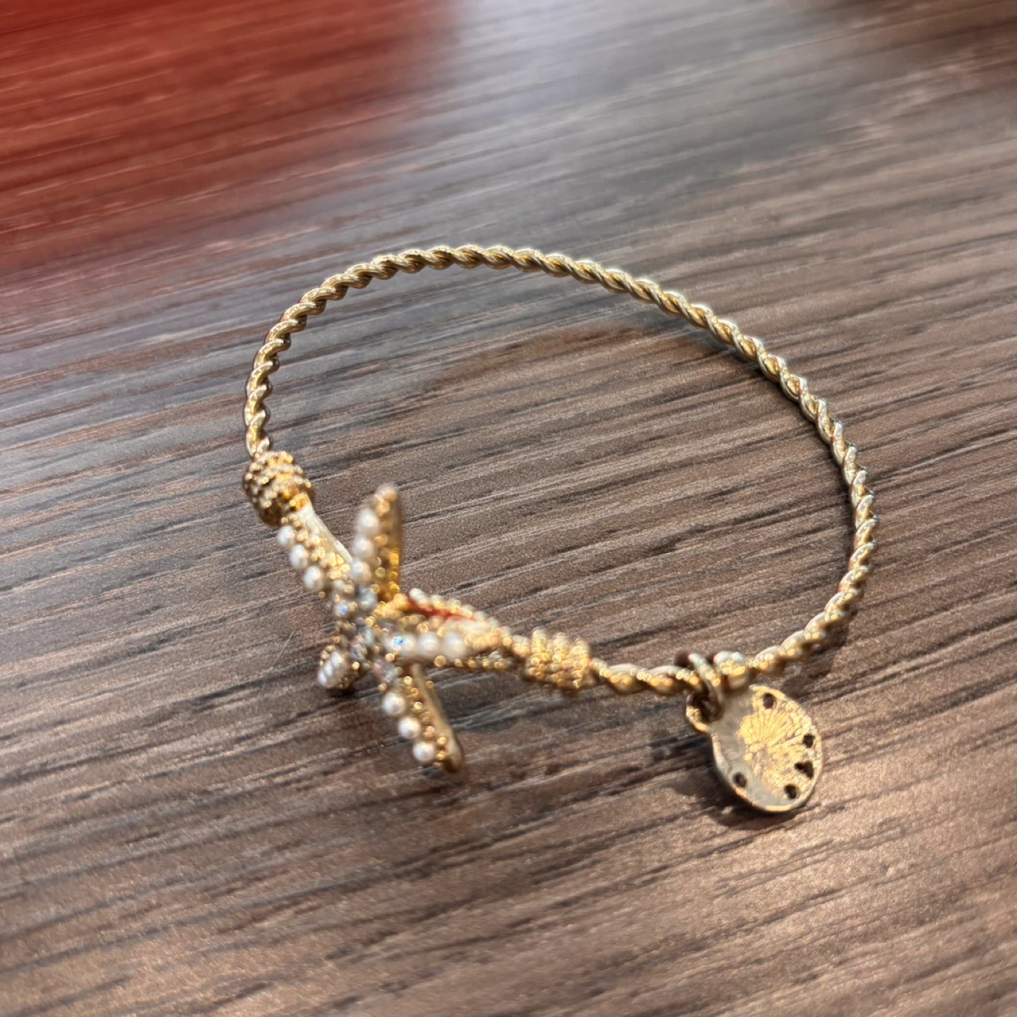 Gold tone starfish bracelet with pearl and rhinestone accents