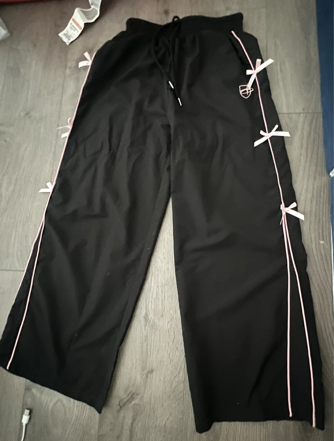 Black track pants with pink trim and bows