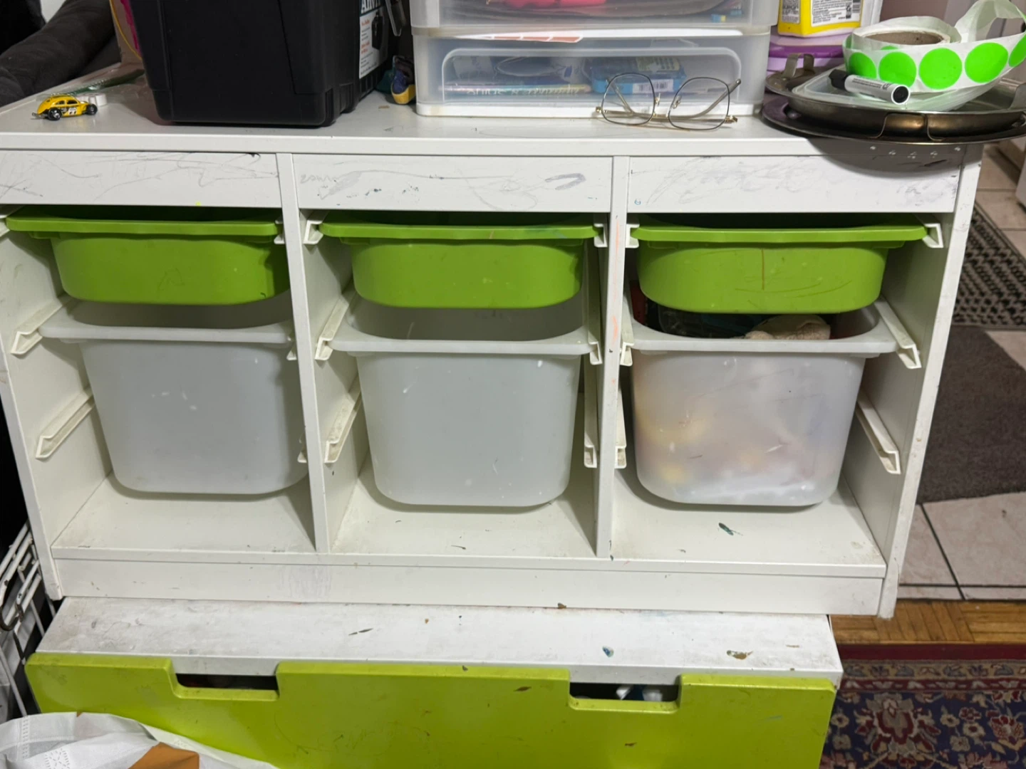 White cube storage unit with green and grey bins