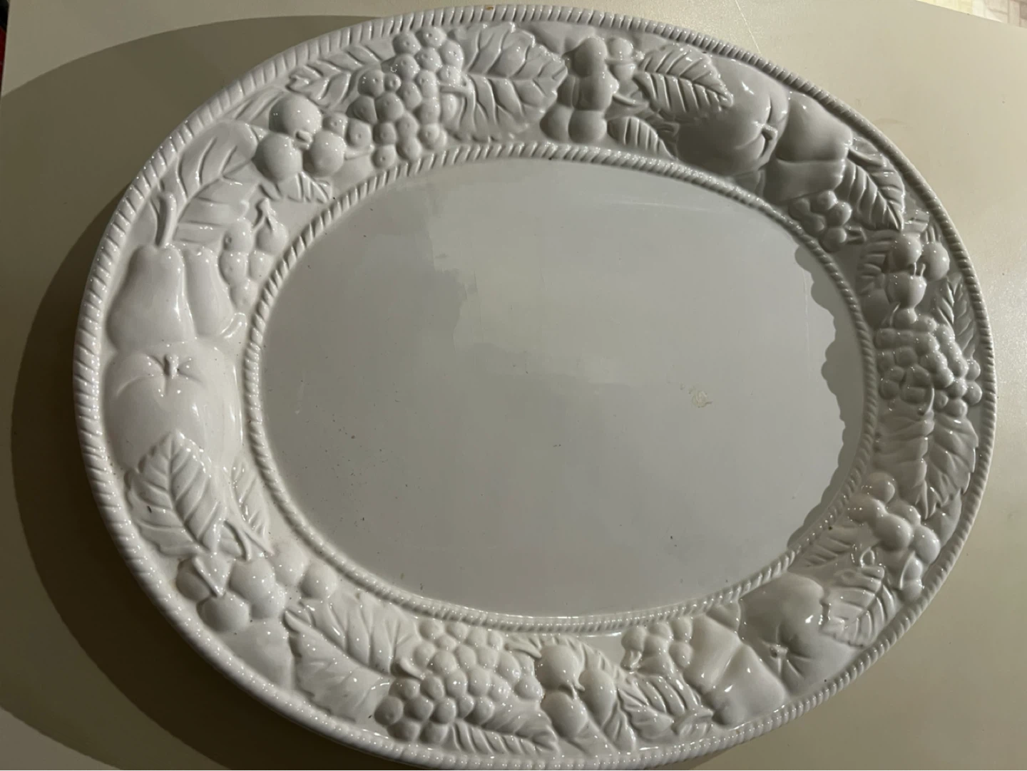 White oval platter with fruit and vine embossed rim