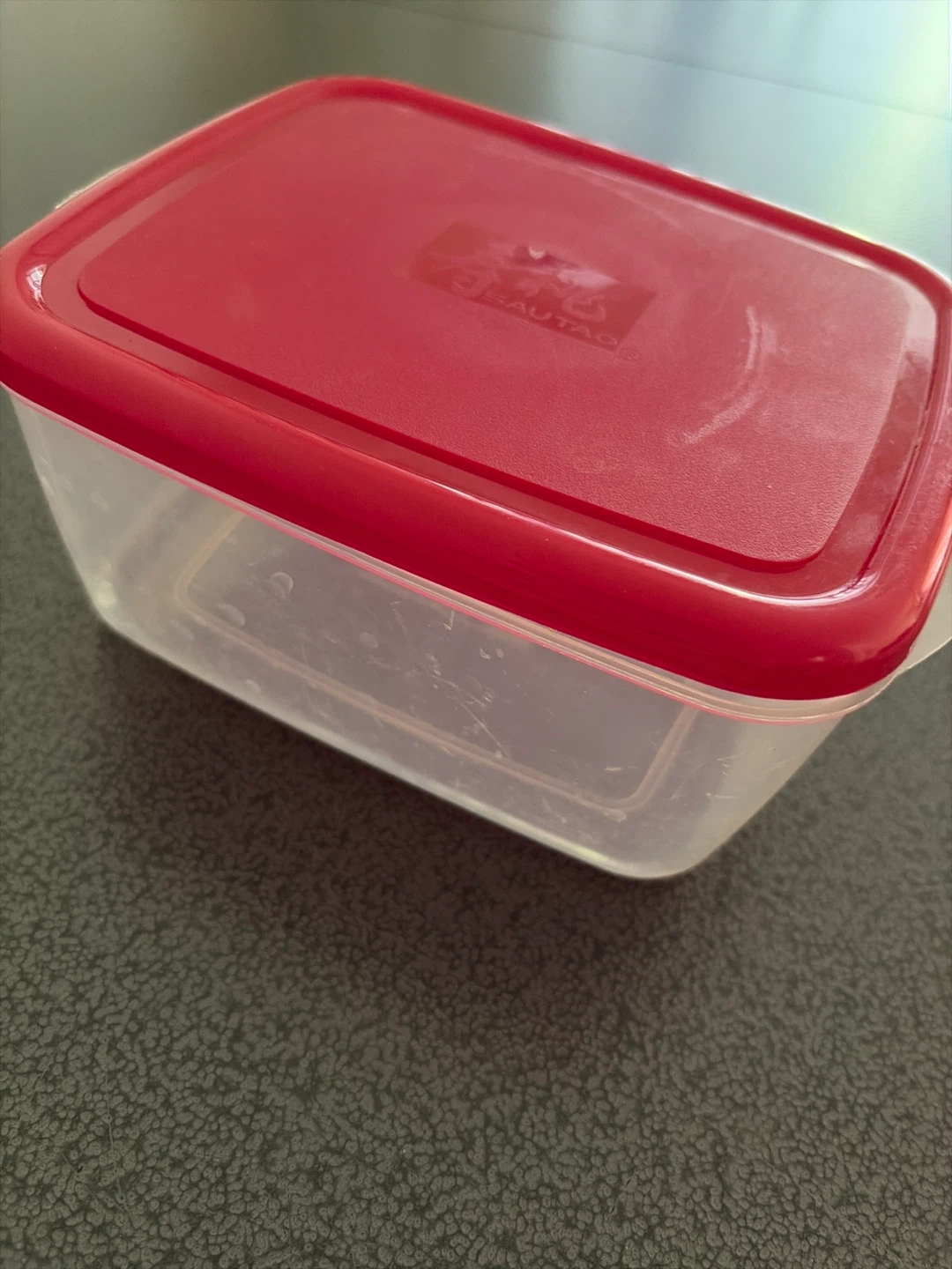Plastic food storage container with red lid