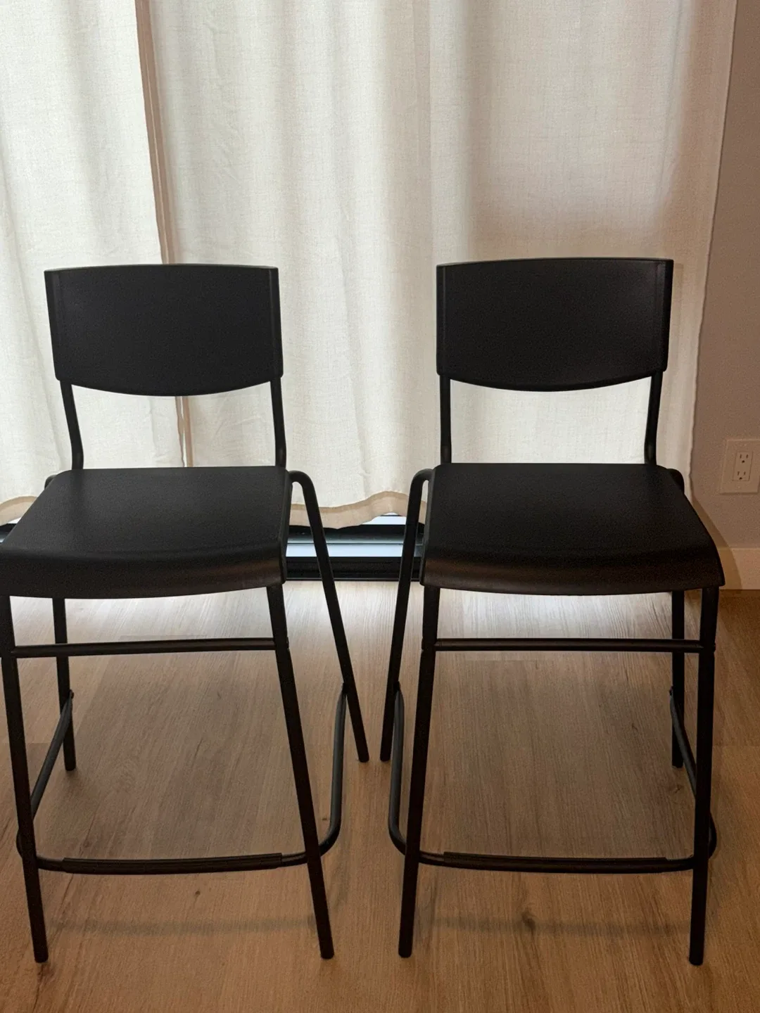 Set of 2 IKEA STIG bar stools with backrest in black.
