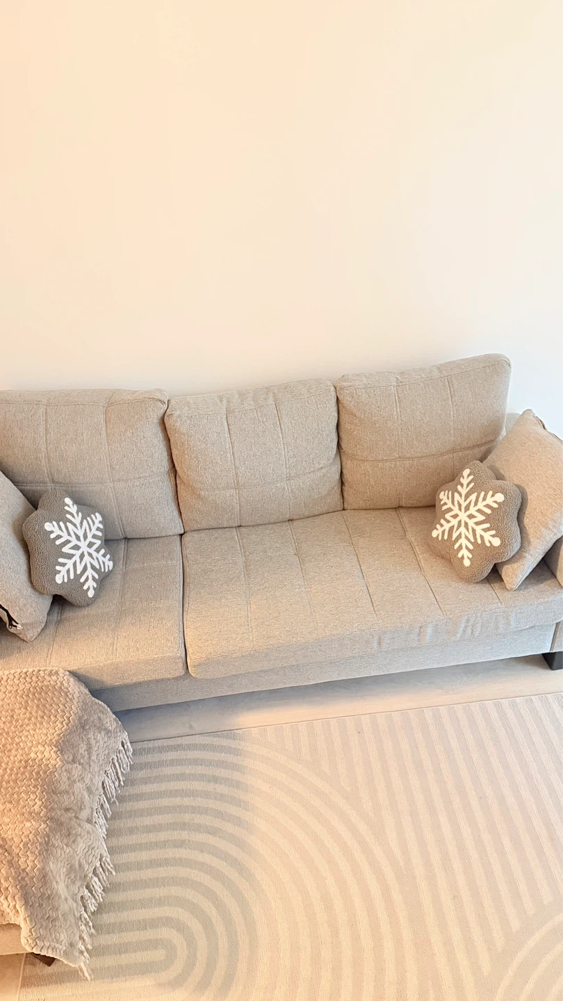 Sofa with throw blanket and snowflake pillows