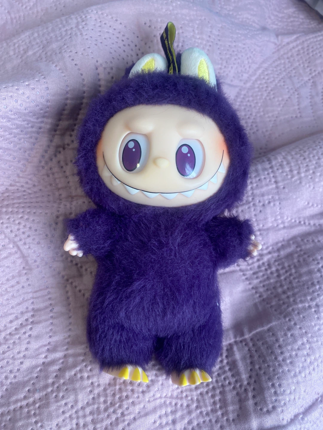Purple Labubu toy with dress