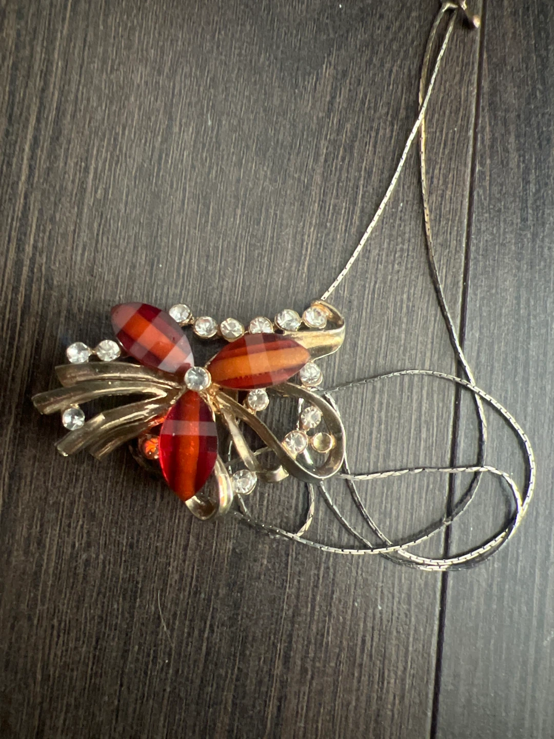 Gold-tone brooch with red and orange stones and clear crystals