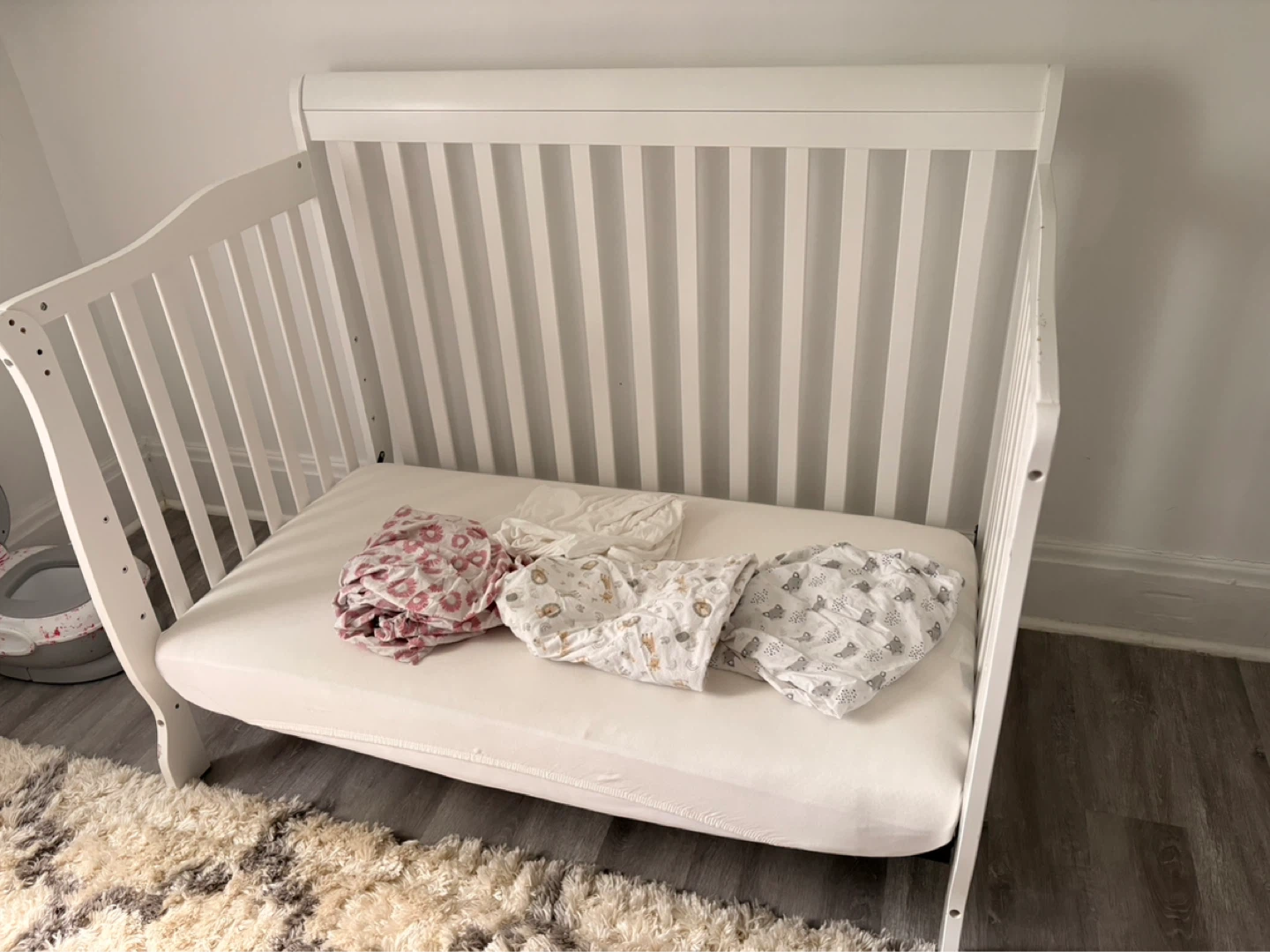 White Dream-On-Me Crib with 5 fitted bedsheets and a mattress