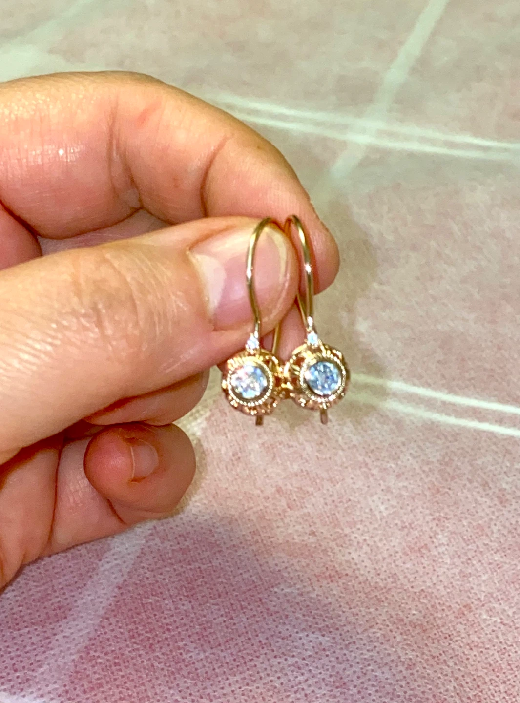 Gold tone dangle earrings with clear stones
