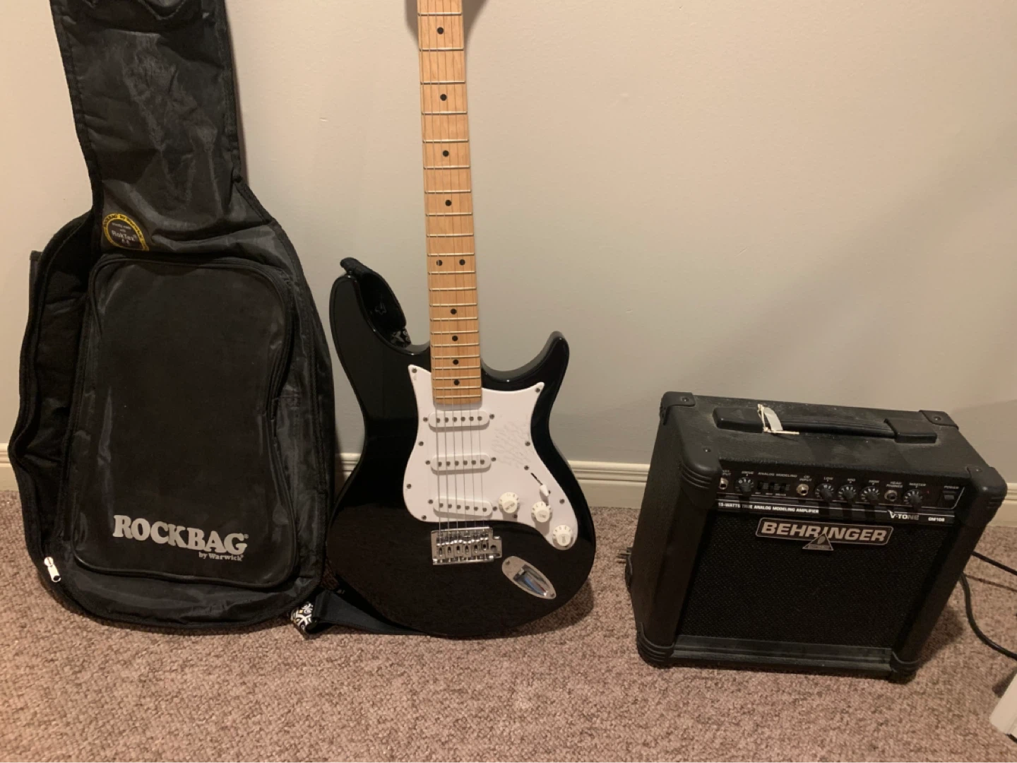 Black electric guitar, amplifier and case trio