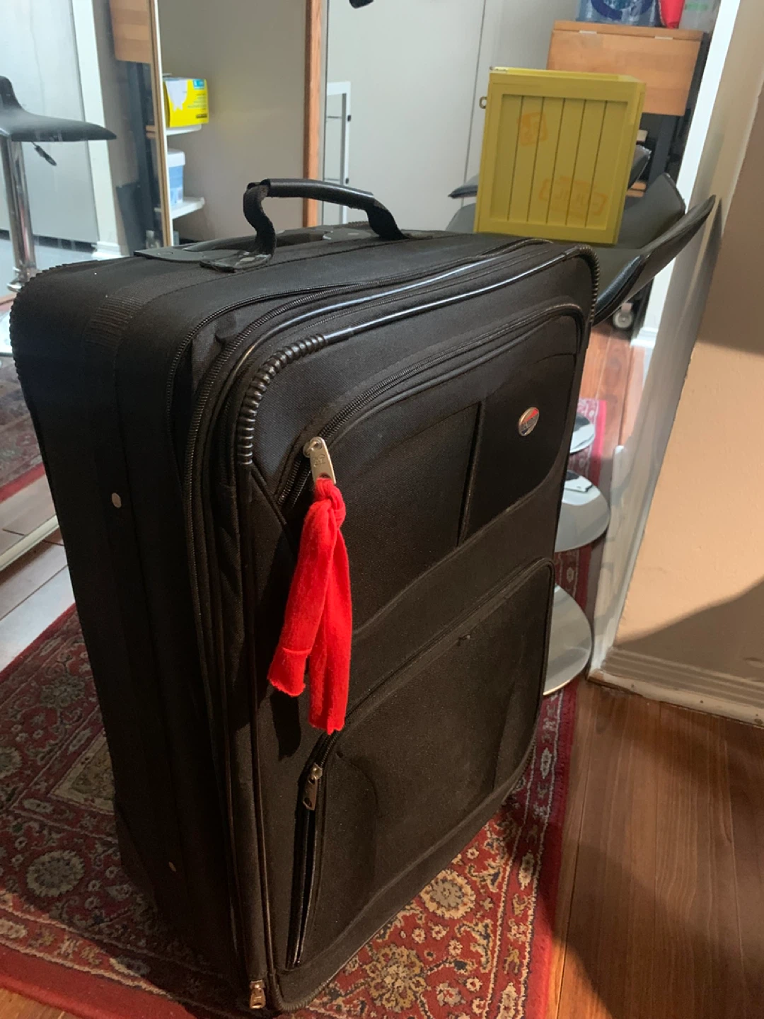 Black softside suitcase with red tassel charm