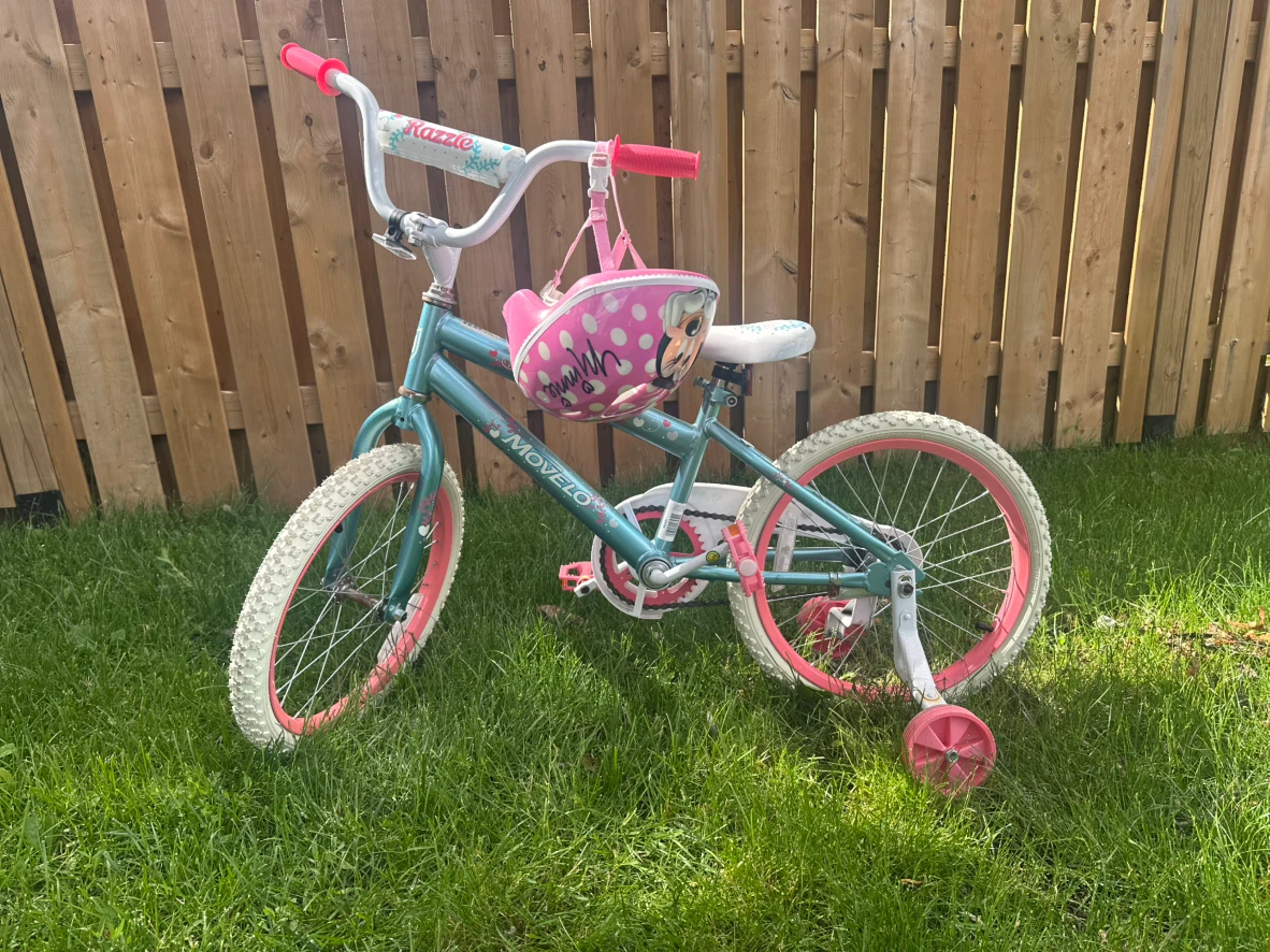 Girls bicycle with training wheels and helmet