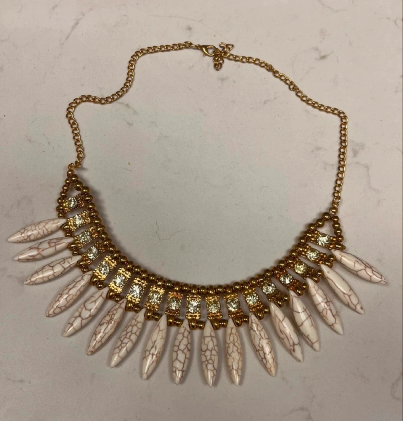 Gold tone statement necklace with white agate-like pendants