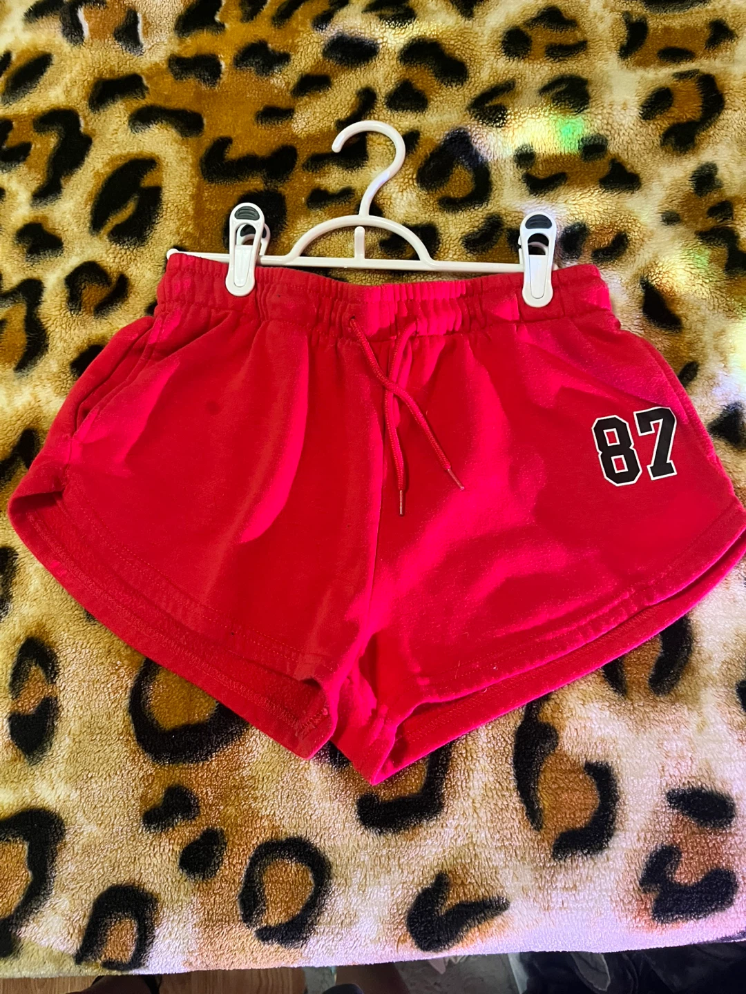 Red athletic shorts with '87' graphic