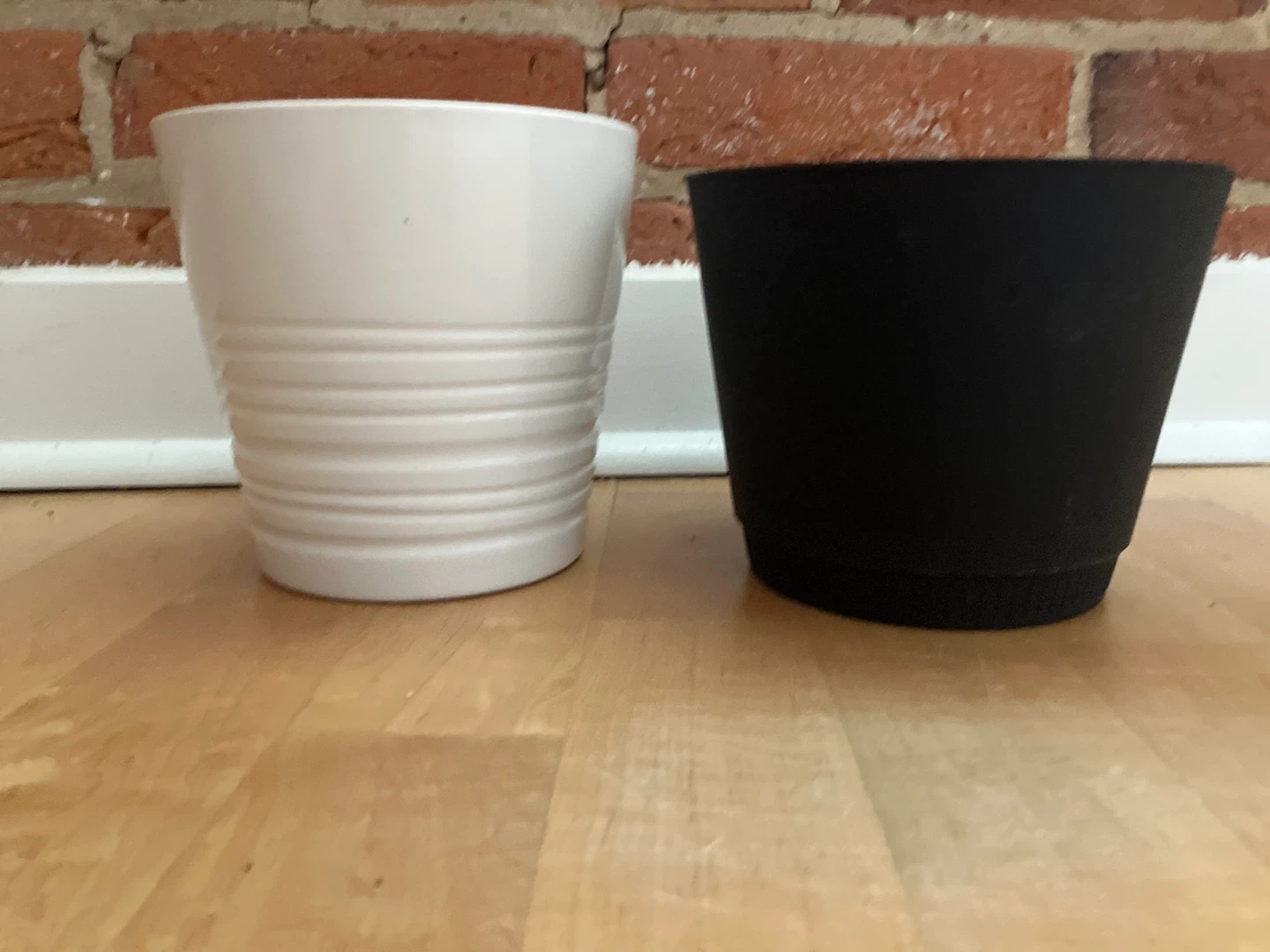 Two plant pots: white ribbed and black