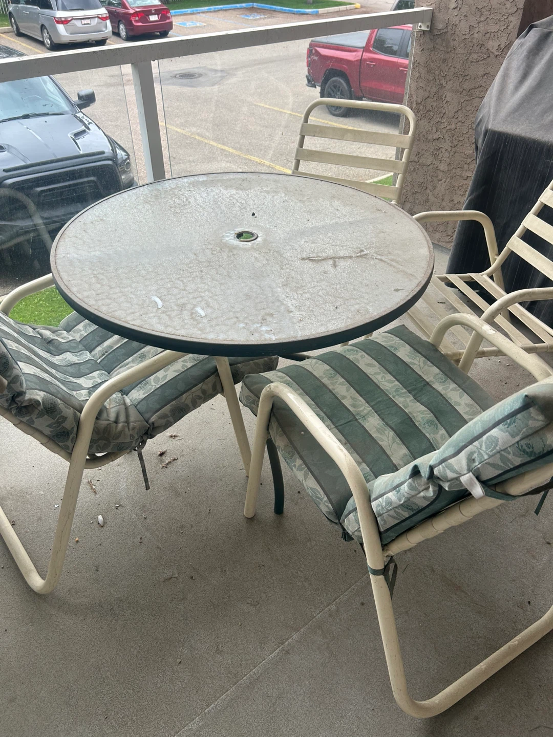 Patio table with four chairs and two cushions