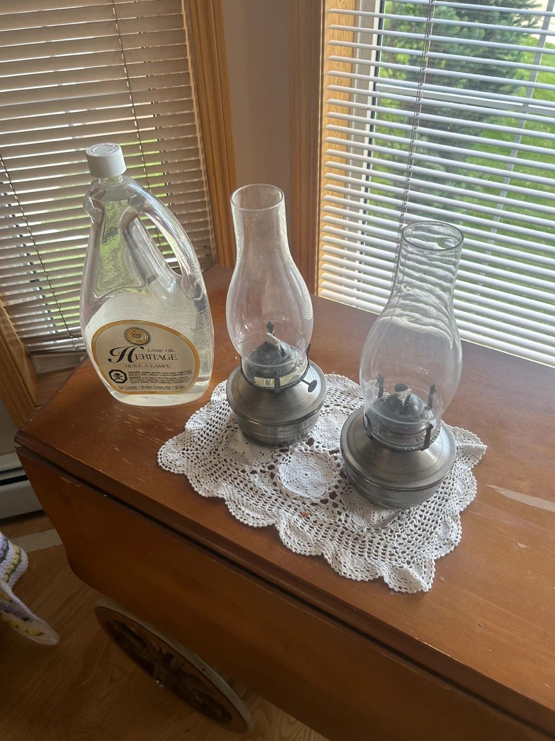2 oil lamps with a bottle of lamp oil