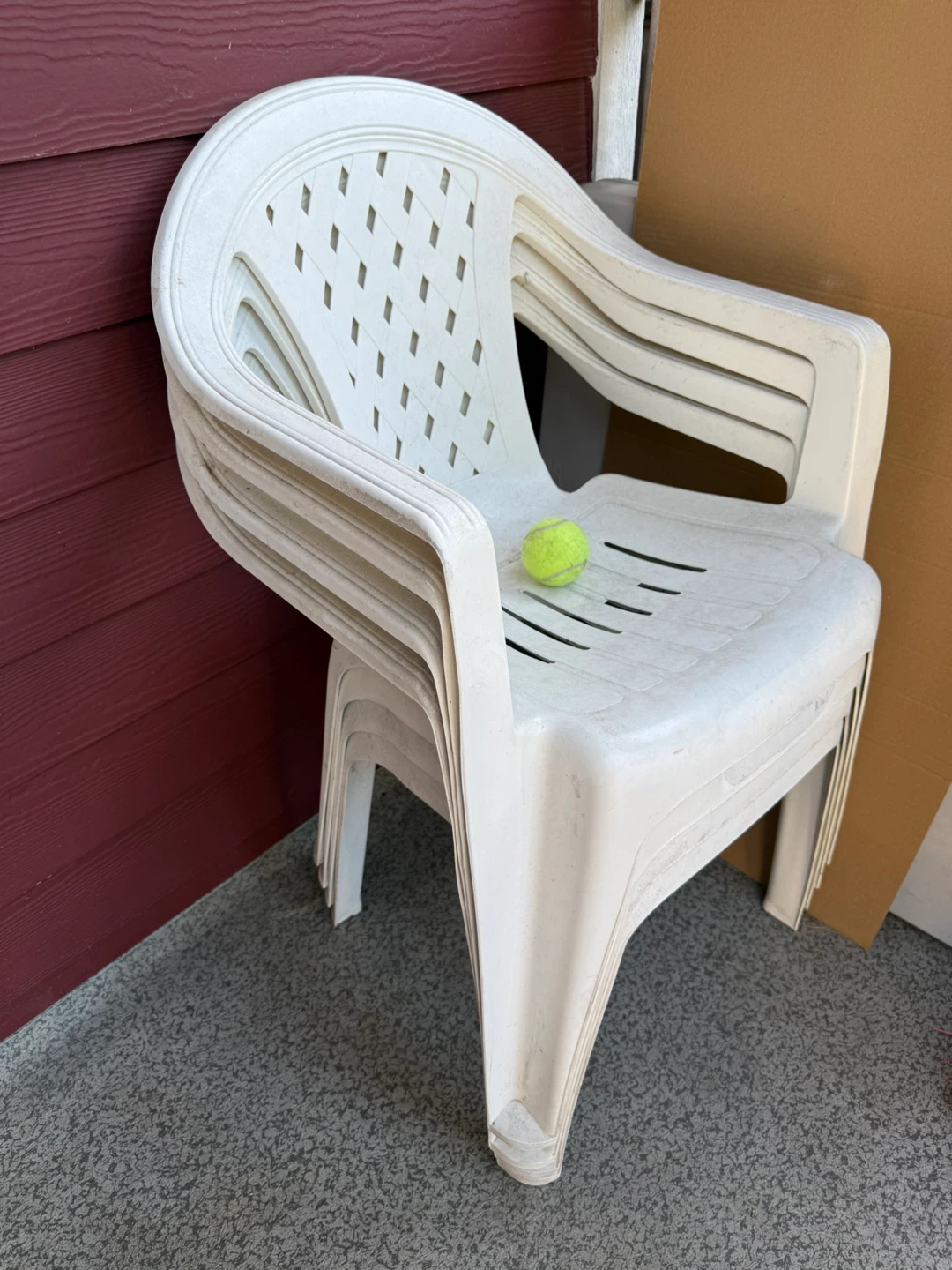 Stack of white plastic outdoor chairs