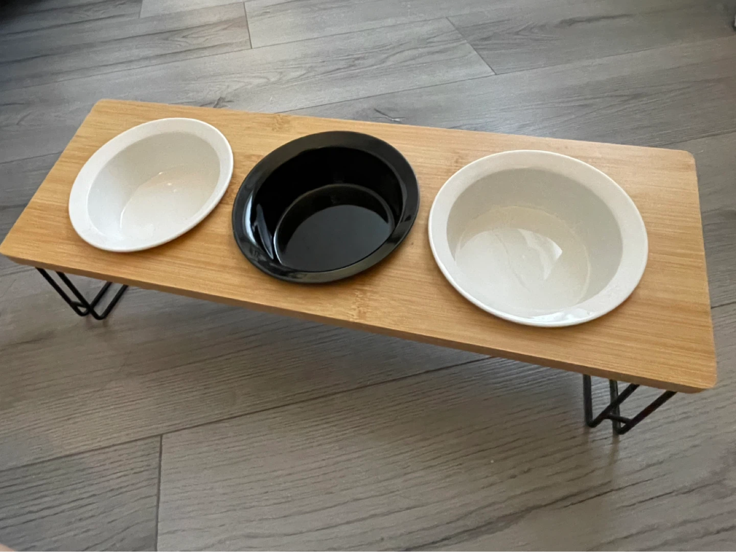 Elevated cat bowl with three ceramic bowls.
