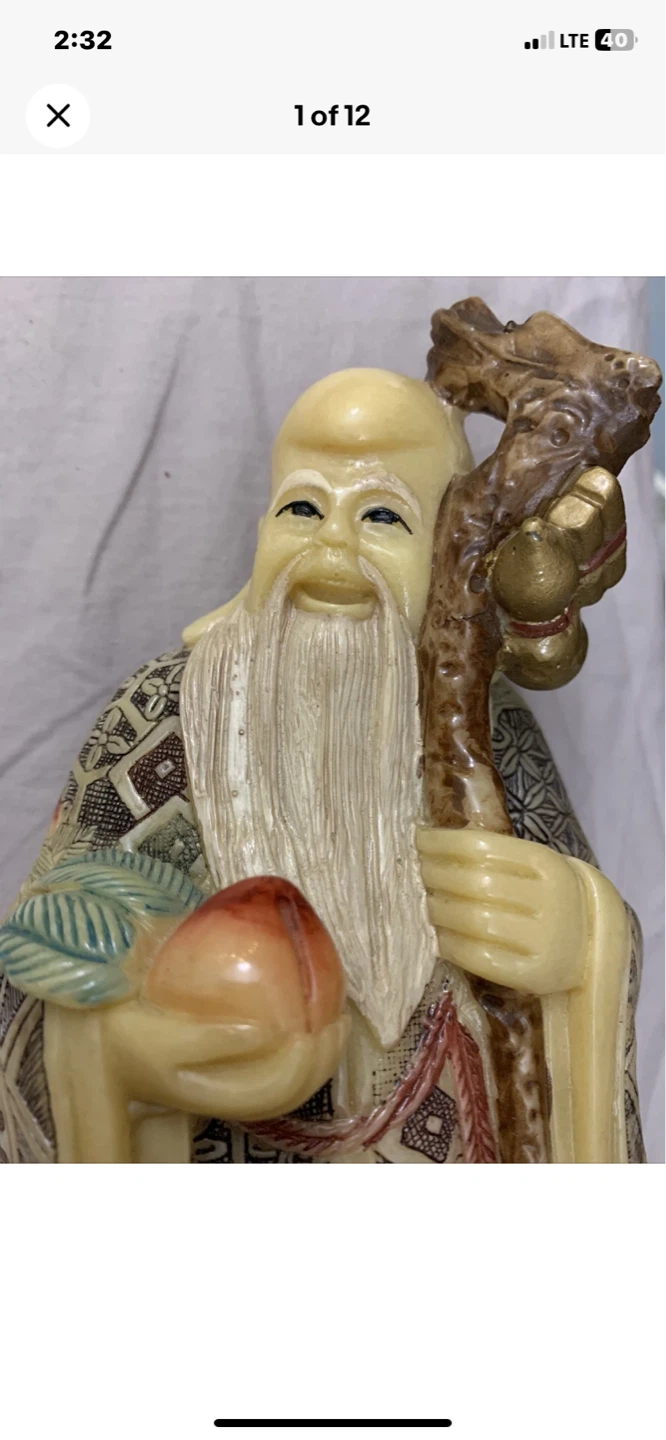 Figurine of an elder holding a peach and staff