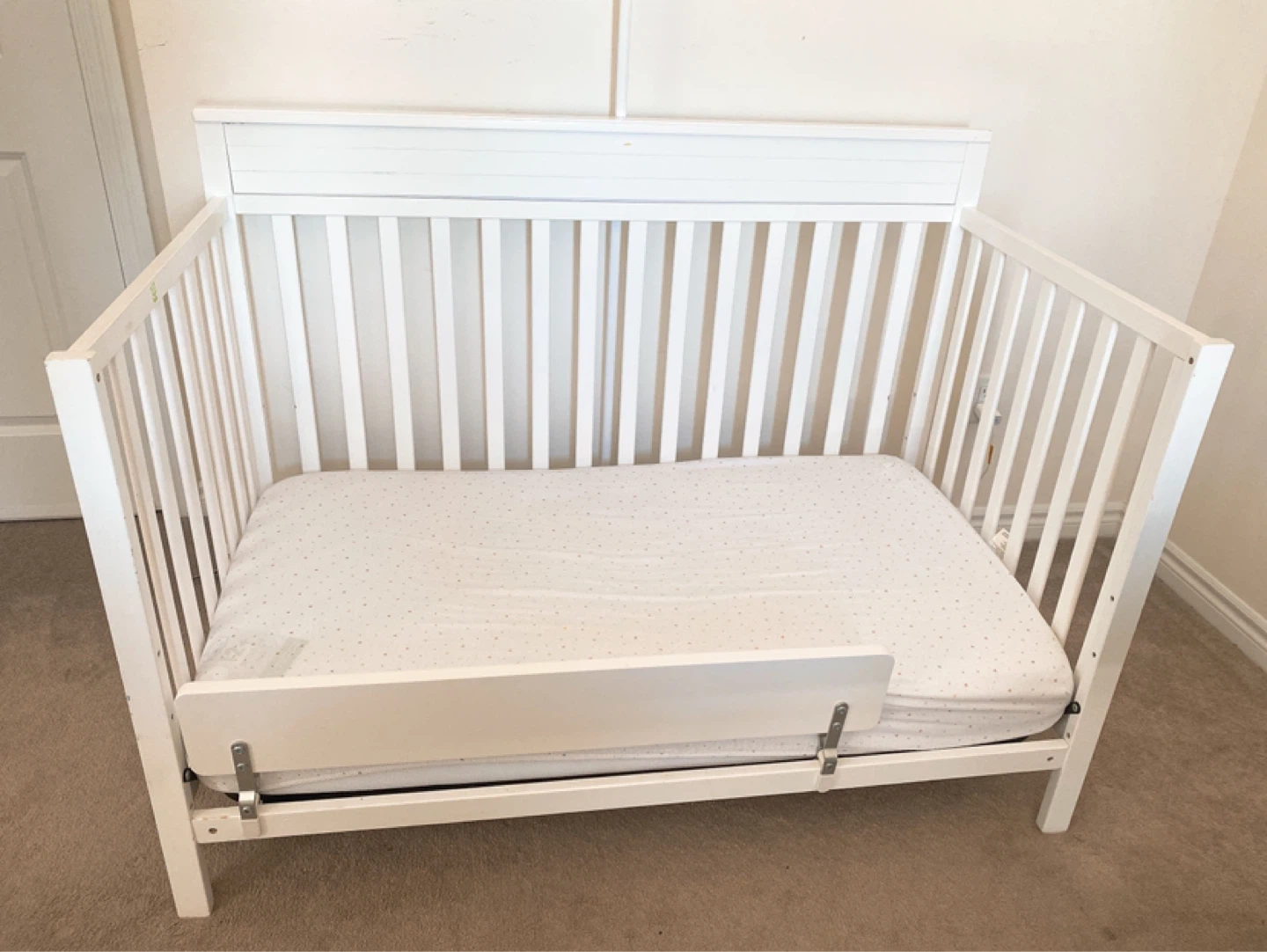 White crib with guard rail