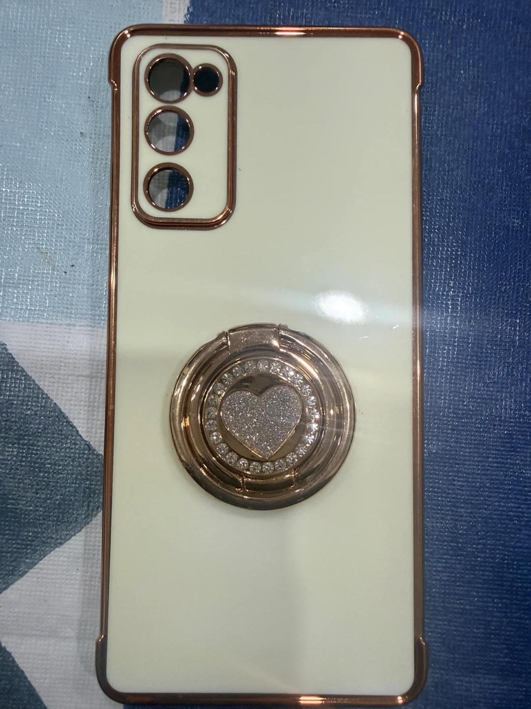 Cream coloured phone case with rose gold trim and ring holder