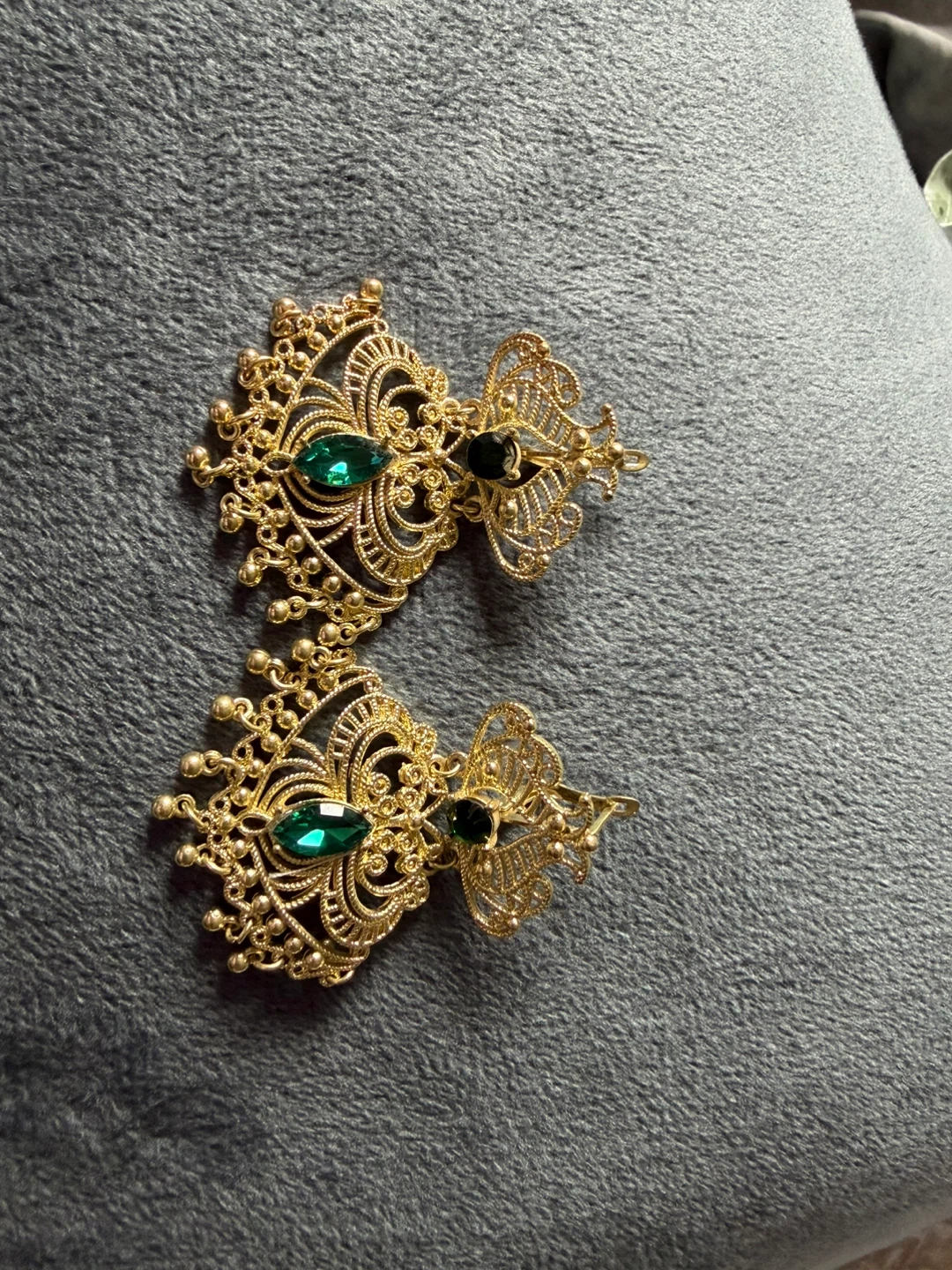 Gold tone intricate earrings with green stones