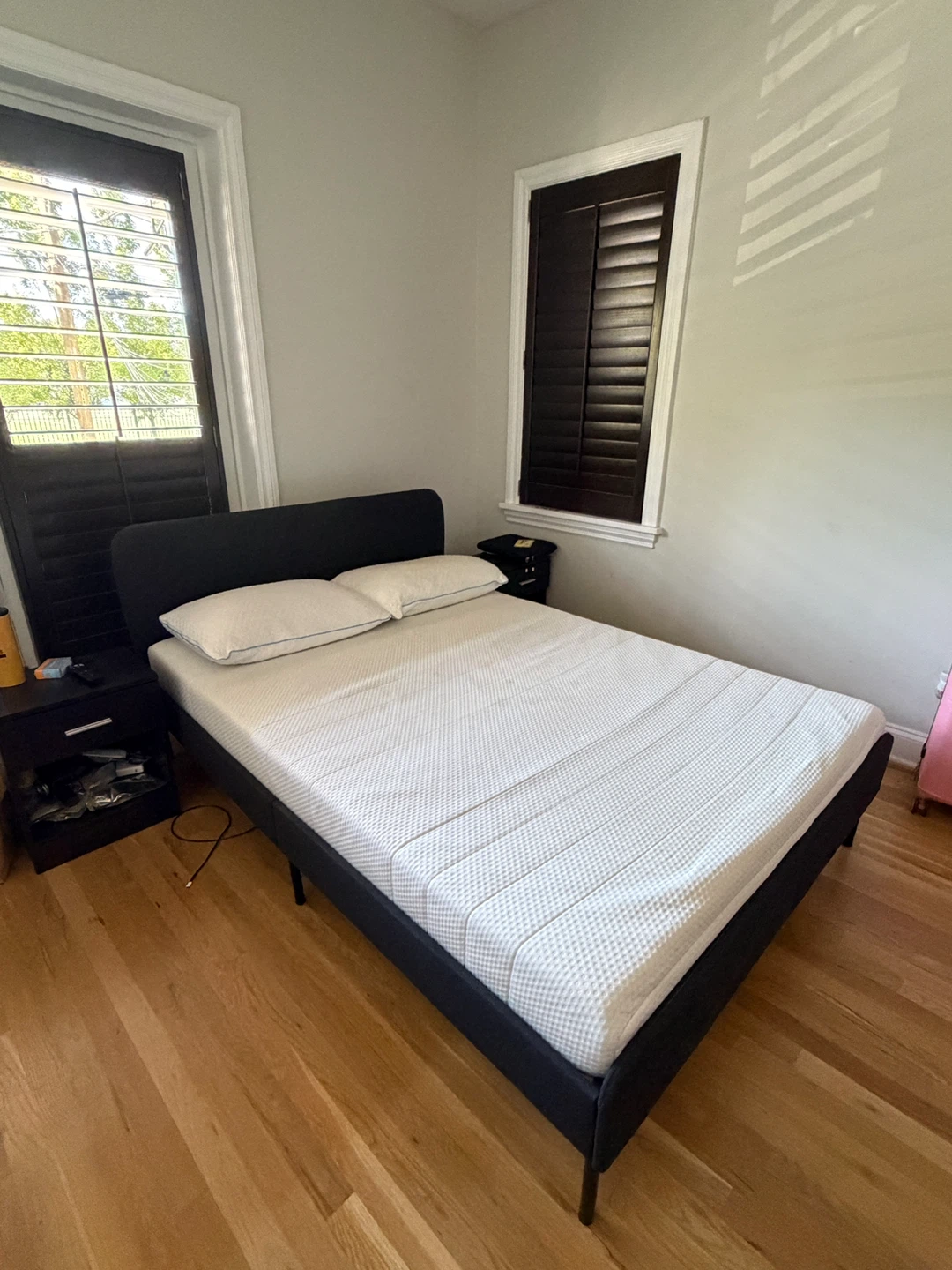 IKEA upholstered bed frame with mattress and pillows