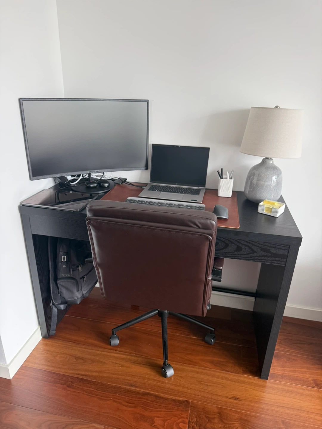 Black Desk with Brown Leather Office Chair and Monitor