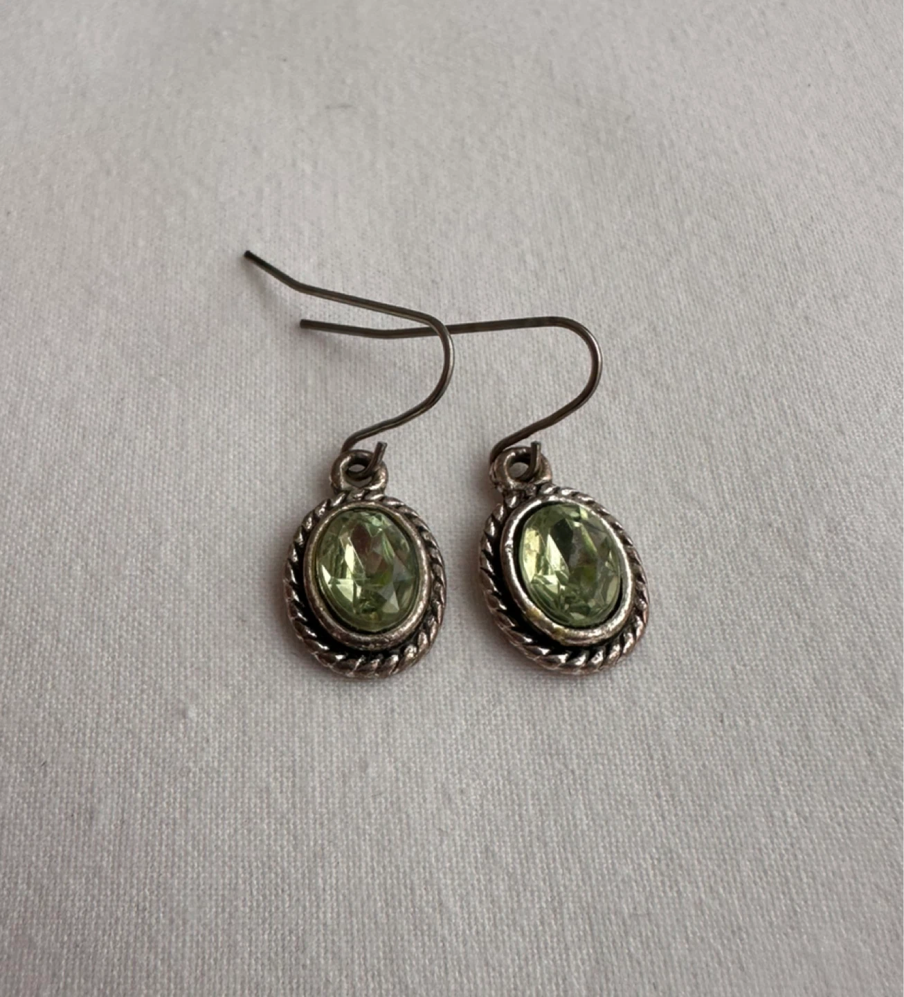 Silver tone drop earrings with green oval stones