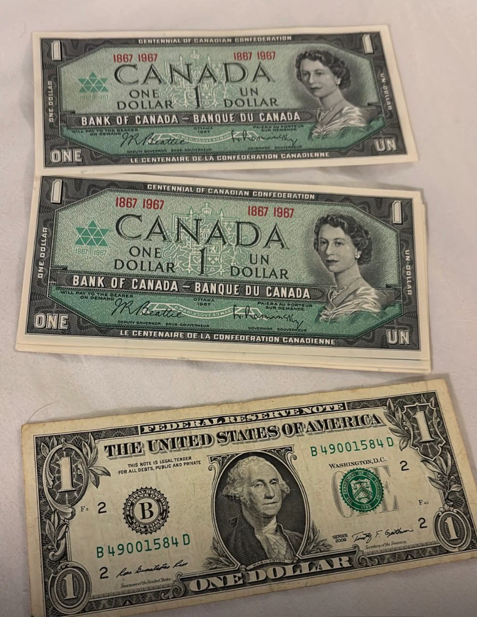 4 Canadian 1 Dollar Bills & One US 1 Dollar Bill