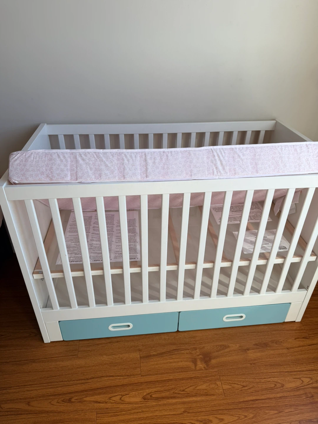 White Baby Crib with Pink Mattress and Storage Drawers