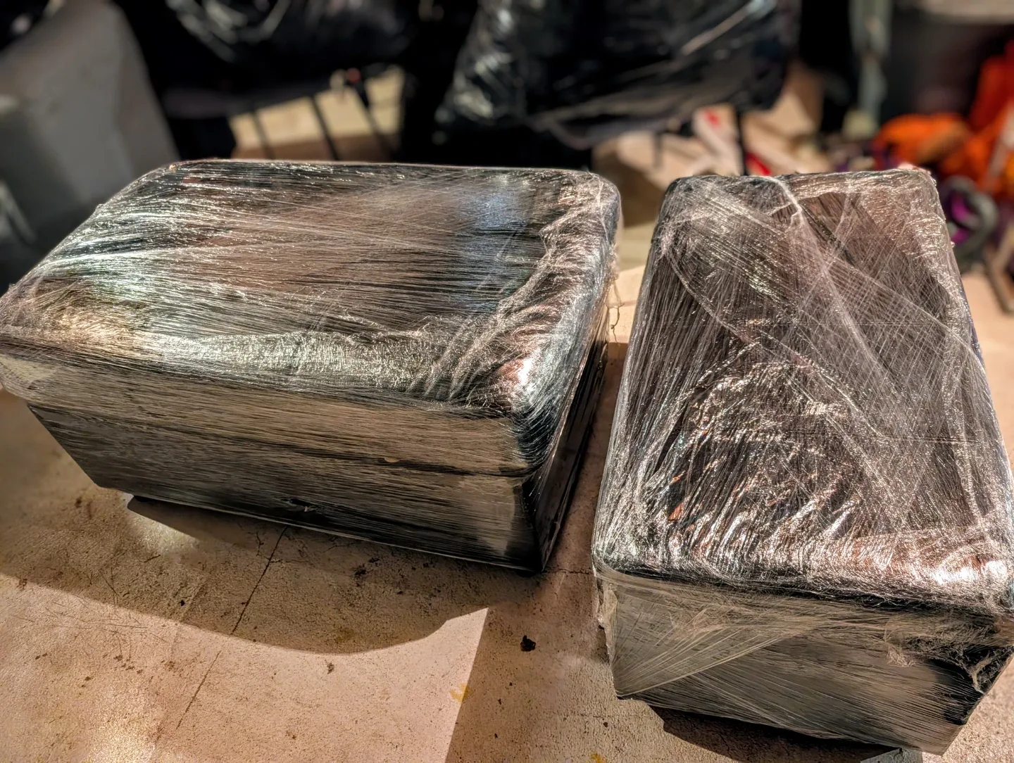 A set of Two black storage boxes with leather sitting