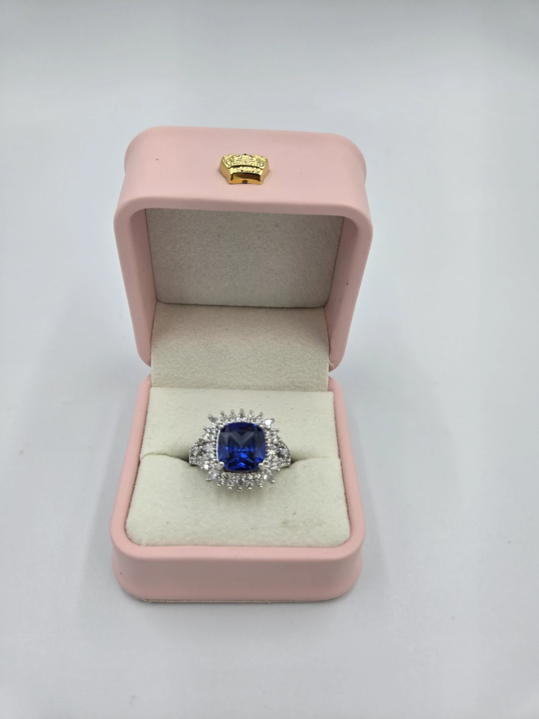 Blue cushion cut halo ring with pink box